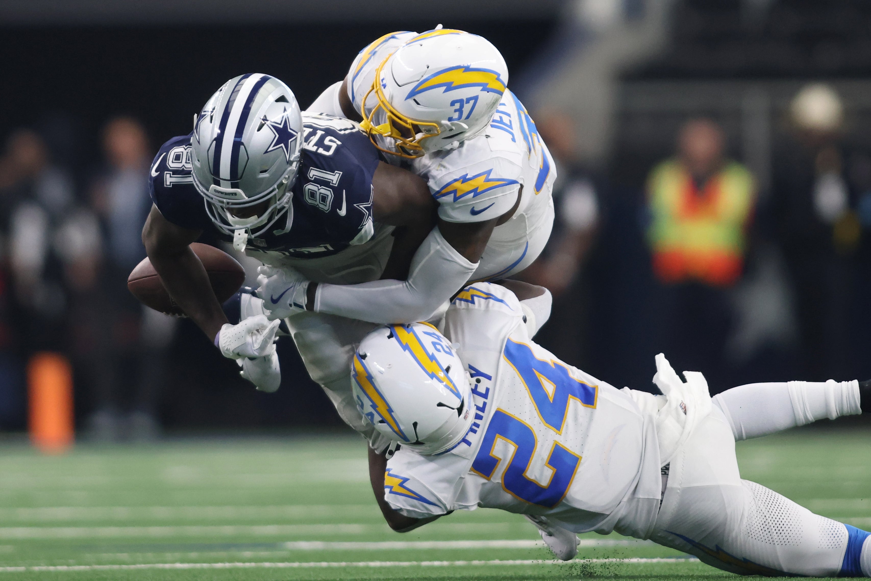 Dallas Cowboys tight end John Stephens Jr. (81) fumbles the ball after being tackled by Los Angeles Chargers safety Thomas Harper (37) and safety AJ Finley (24) in the second quarter at AT&T Stadium.