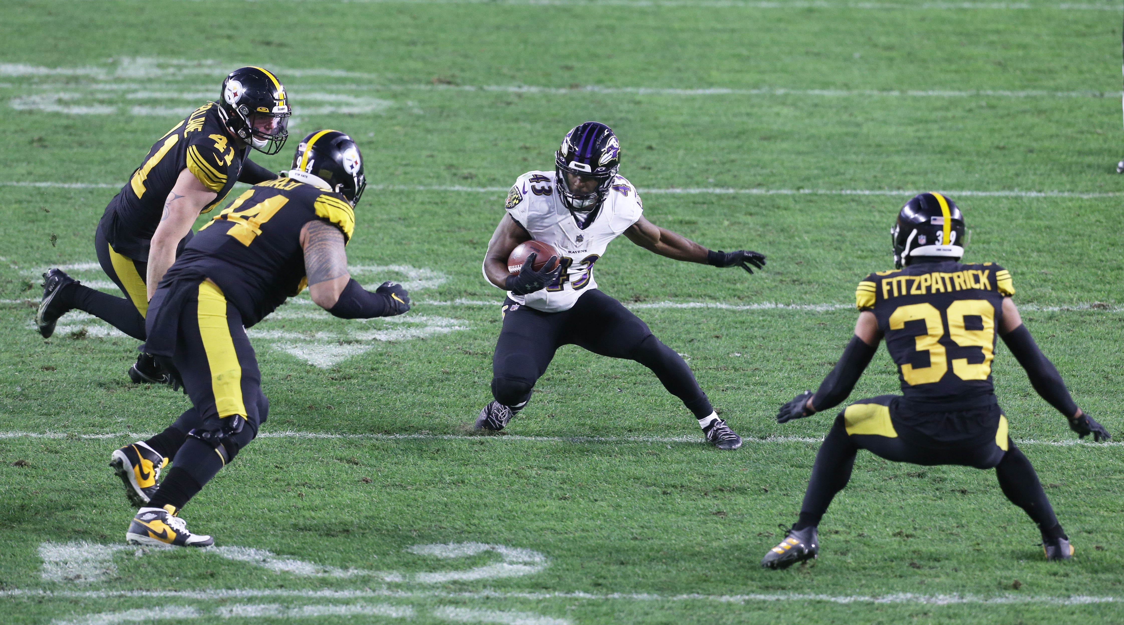 Dec 2, 2020; Pittsburgh, Pennsylvania, USA; Baltimore Ravens running back Justice Hill (43) runs the ball as Pittsburgh Steelers inside linebacker Robert Spillane (41) and nose tackle Tyson Alualu (94) and free safety Minkah Fitzpatrick (39) defend during the second quarter at Heinz Field.