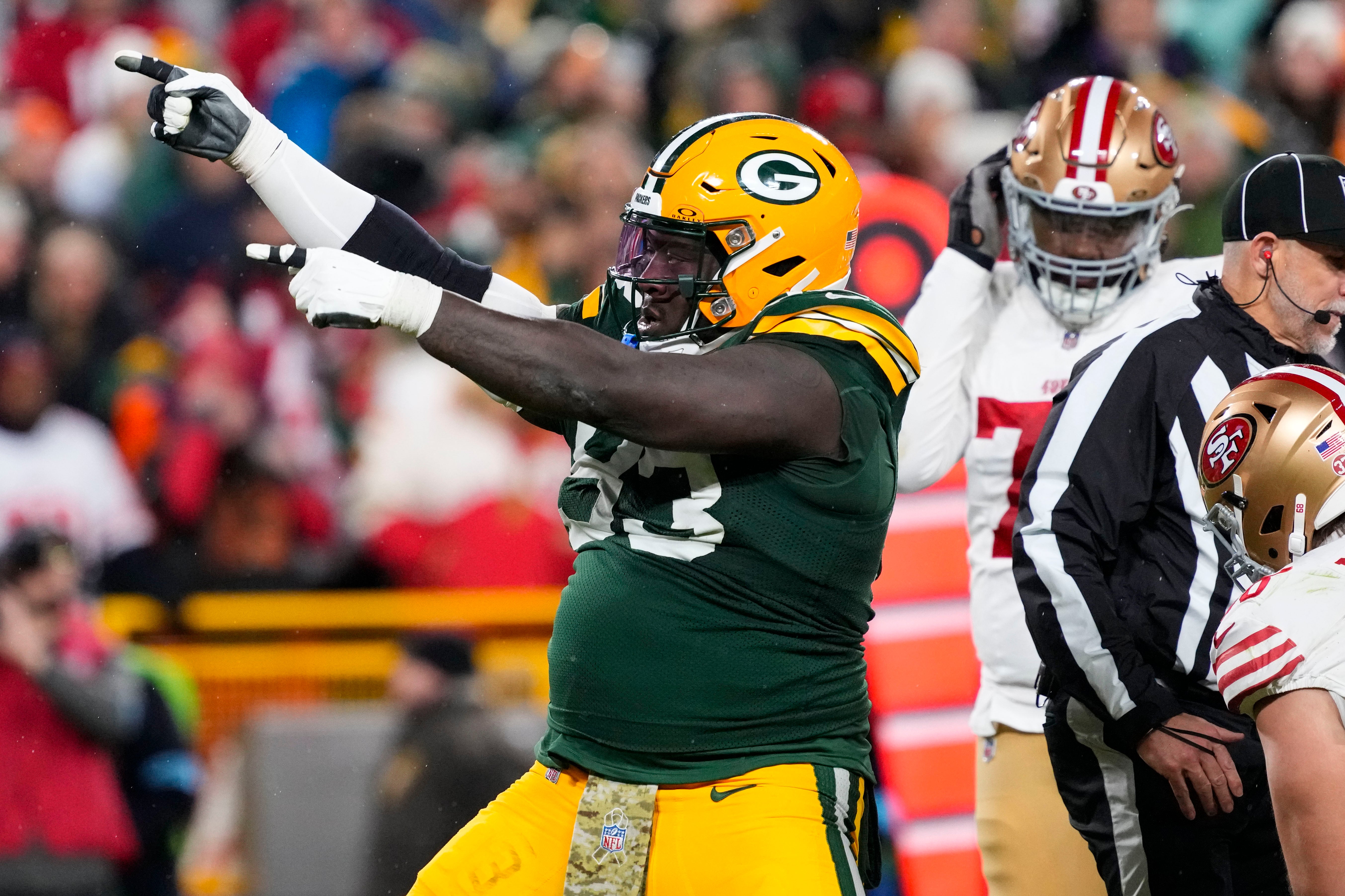 Nov 24, 2024; Green Bay, Wisconsin, USA; Green Bay Packers defensive lineman T.J. Slaton (93) celebrates following a turnover during the fourth quarter against the San Francisco 49ers at Lambeau Field.