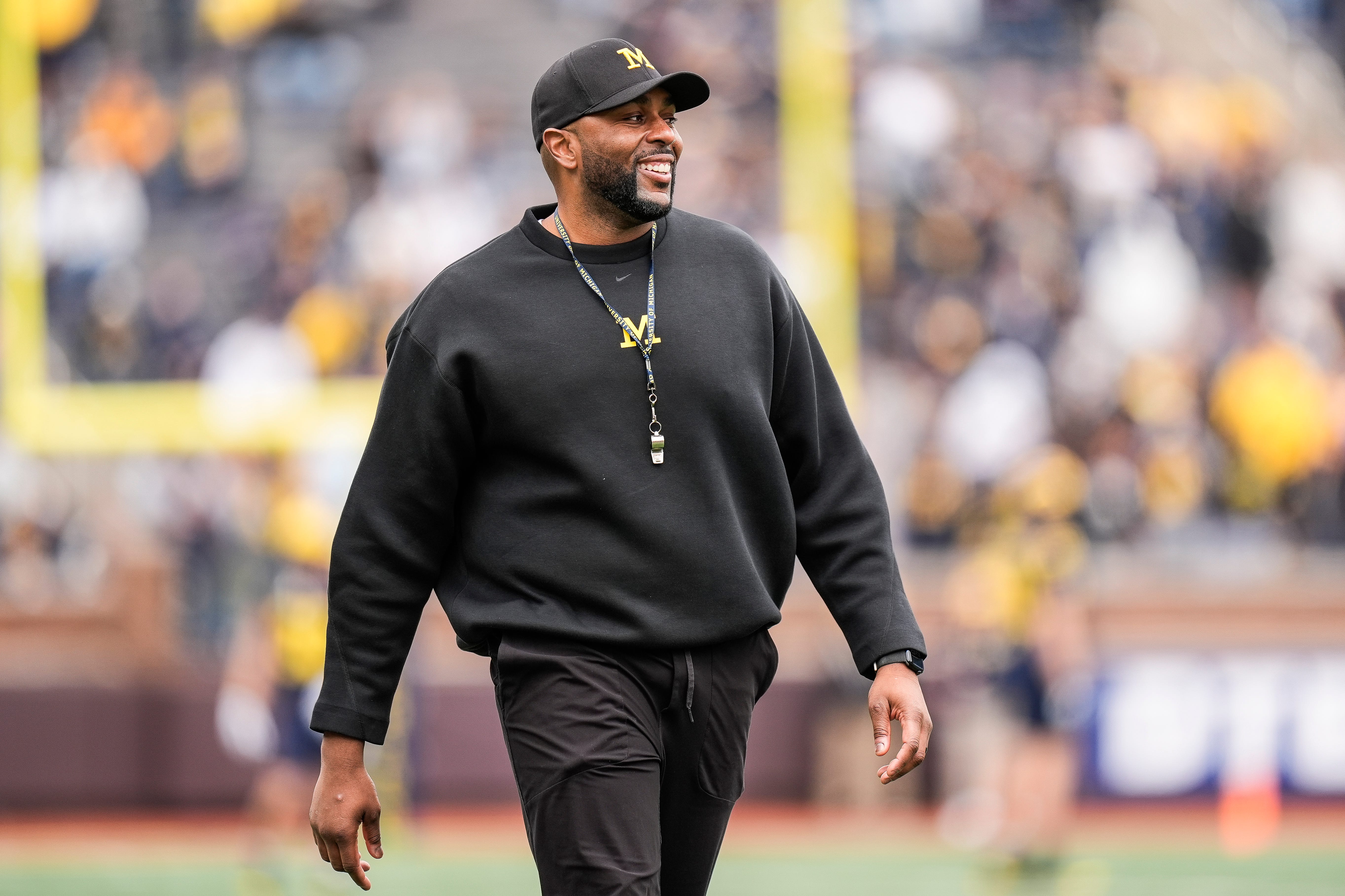 Michigan head coach Sherrone Moore smiles at players as he watches the first half of the spring game at Michigan Stadium in Ann Arbor on Saturday, April 19, 2025.