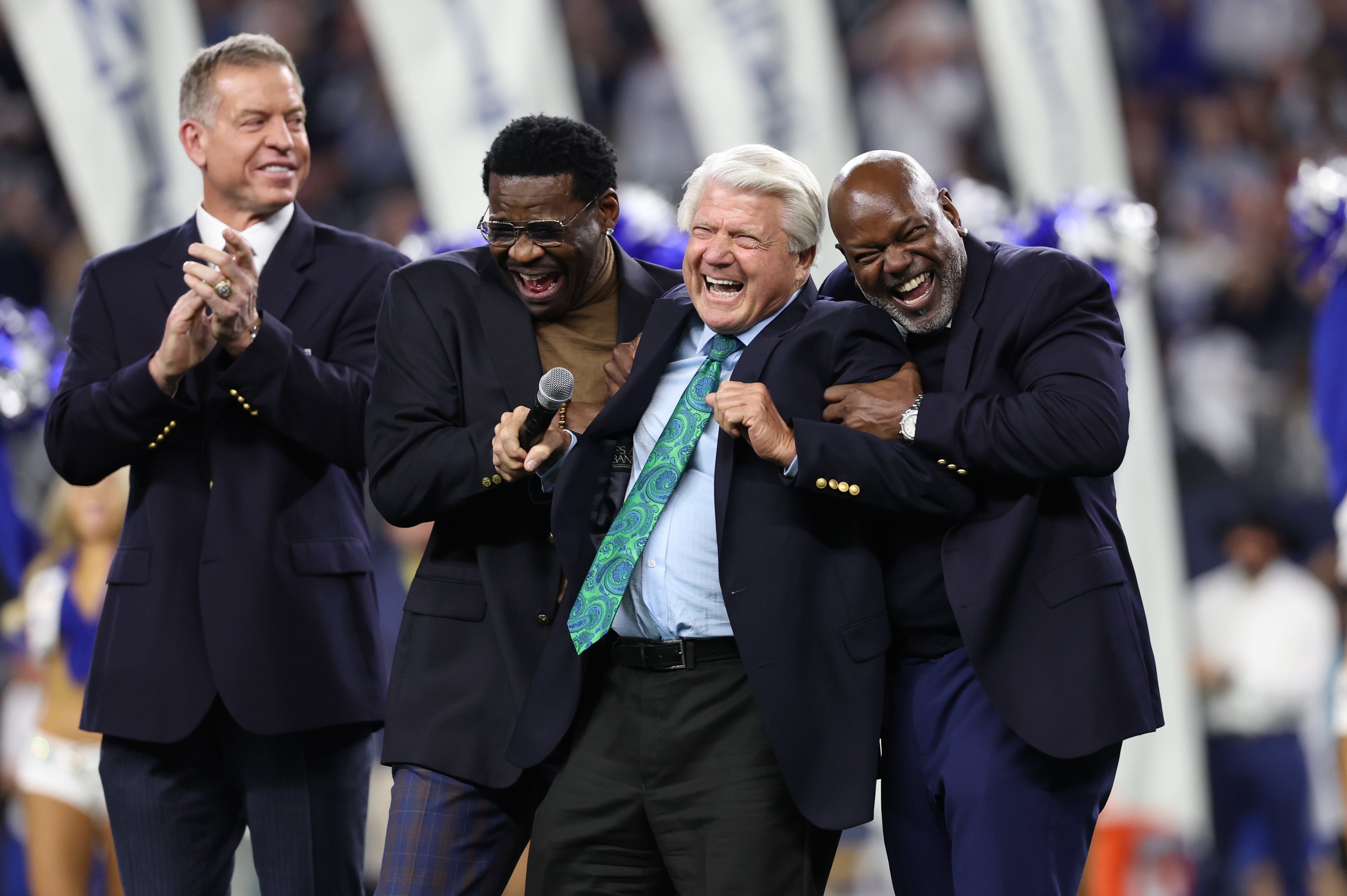 Dallas Cowboys former head coach Jimmy Johnson laughs with former players Troy Aikman and Michael Irvin and Emmitt Smith after being inducted into the ring of honor at halftime of the game against the Detroit Lions at AT&T Stadium.