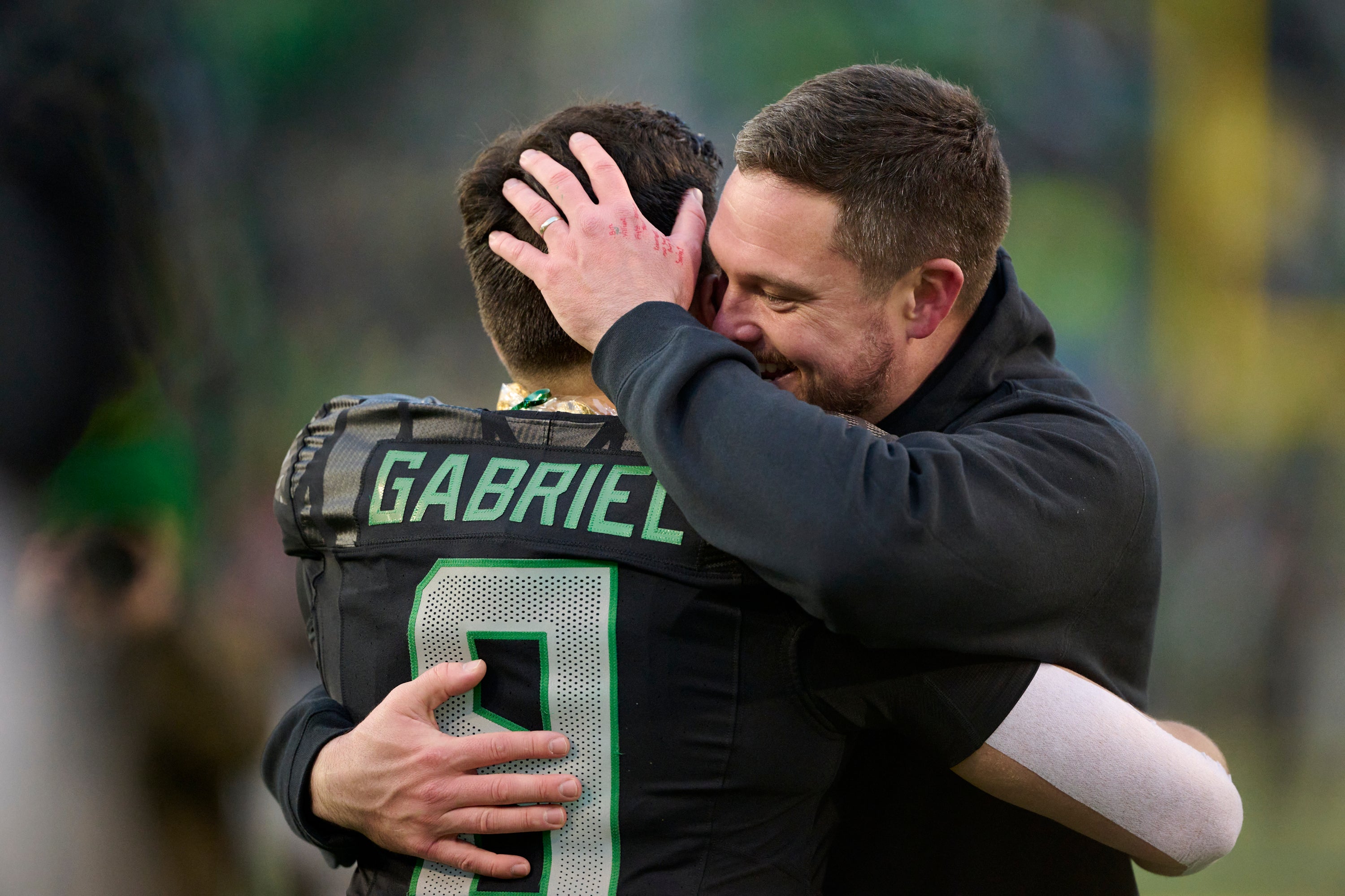 Nov 30, 2024; Eugene, Oregon, USA; Oregon Ducks head coach Dan Lanning celebrates with quarterback Dillon Gabriel (8) during a senior recognizing ceremony before a game against the Washington Huskies at Autzen Stadium. Mandatory Credit: Troy Wayrynen-Imagn Images
