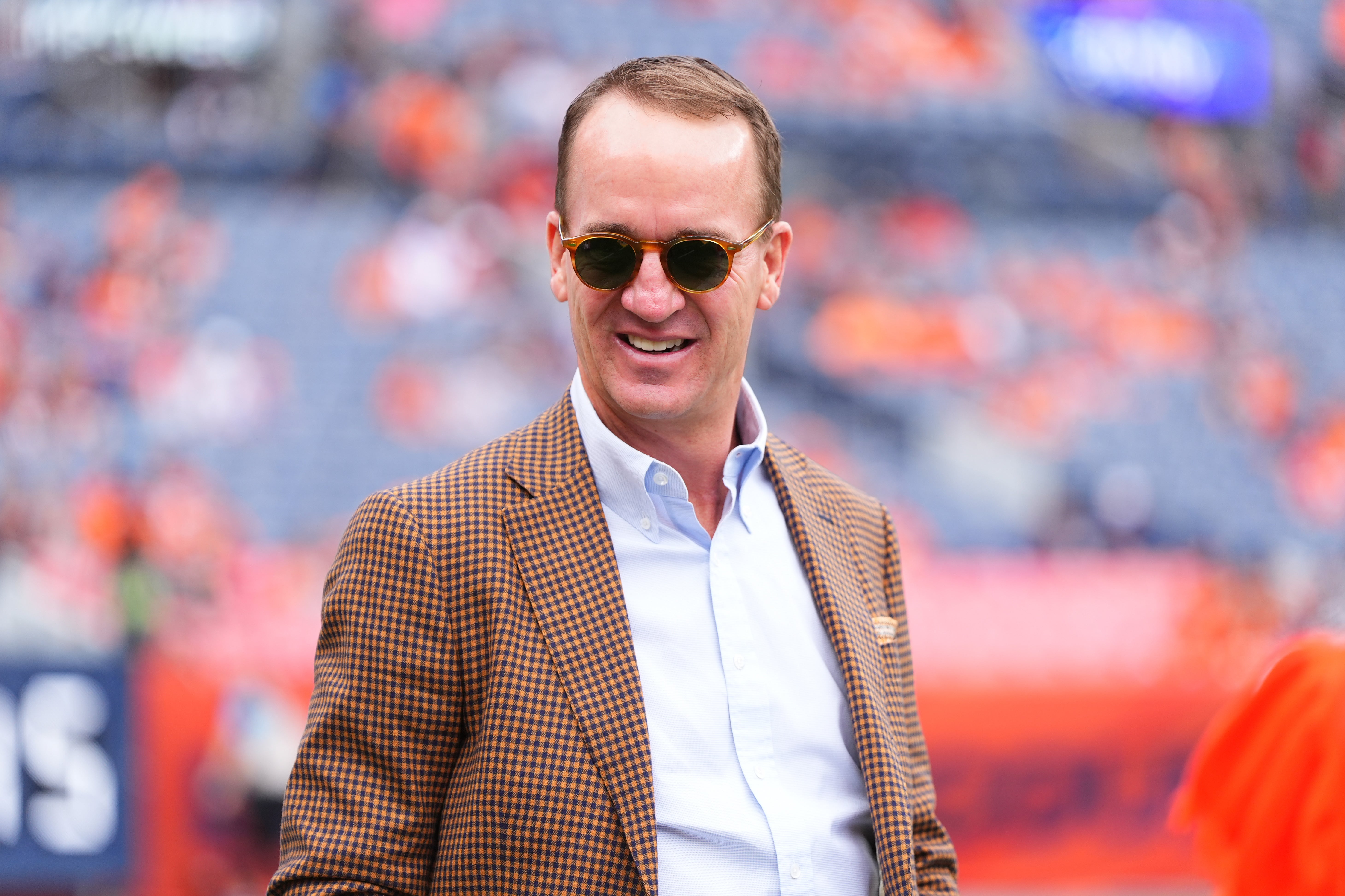 Oct 27, 2024; Denver, Colorado, USA; Retired NFL player Peyton Manning stands on the sidelines of Empower Field at Mile High before the game between the Carolina Panthers Denver Broncos.