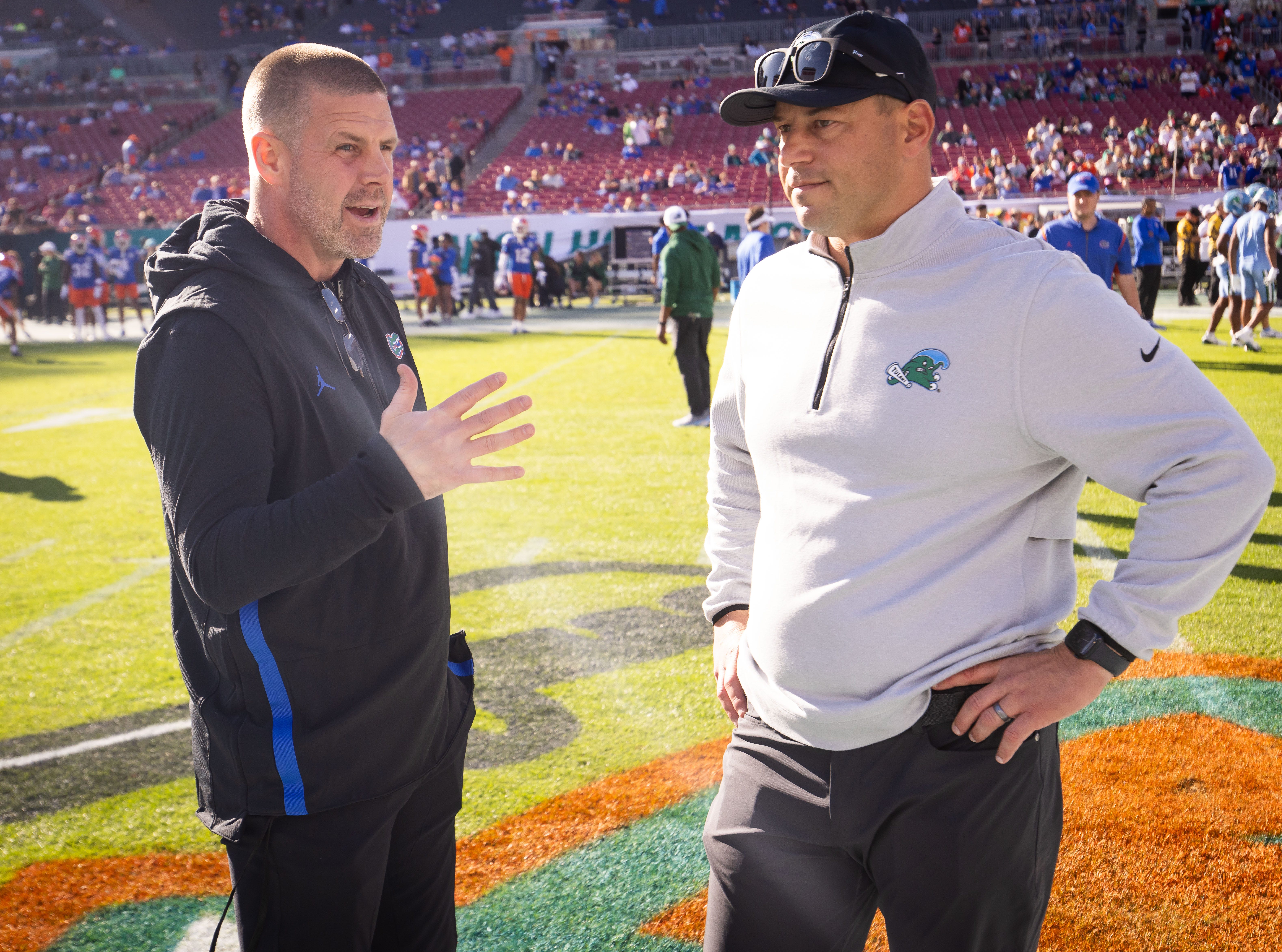 Florida Gators head coach Billy Napier and Tulane Green Wave head coach John Sumrall talk before the start of the game during warmups at Raymond James Stadium in Tampa, FL on Friday, December 20, 2024 in the 2024 Union Home Mortgage Gasparilla Bowl.