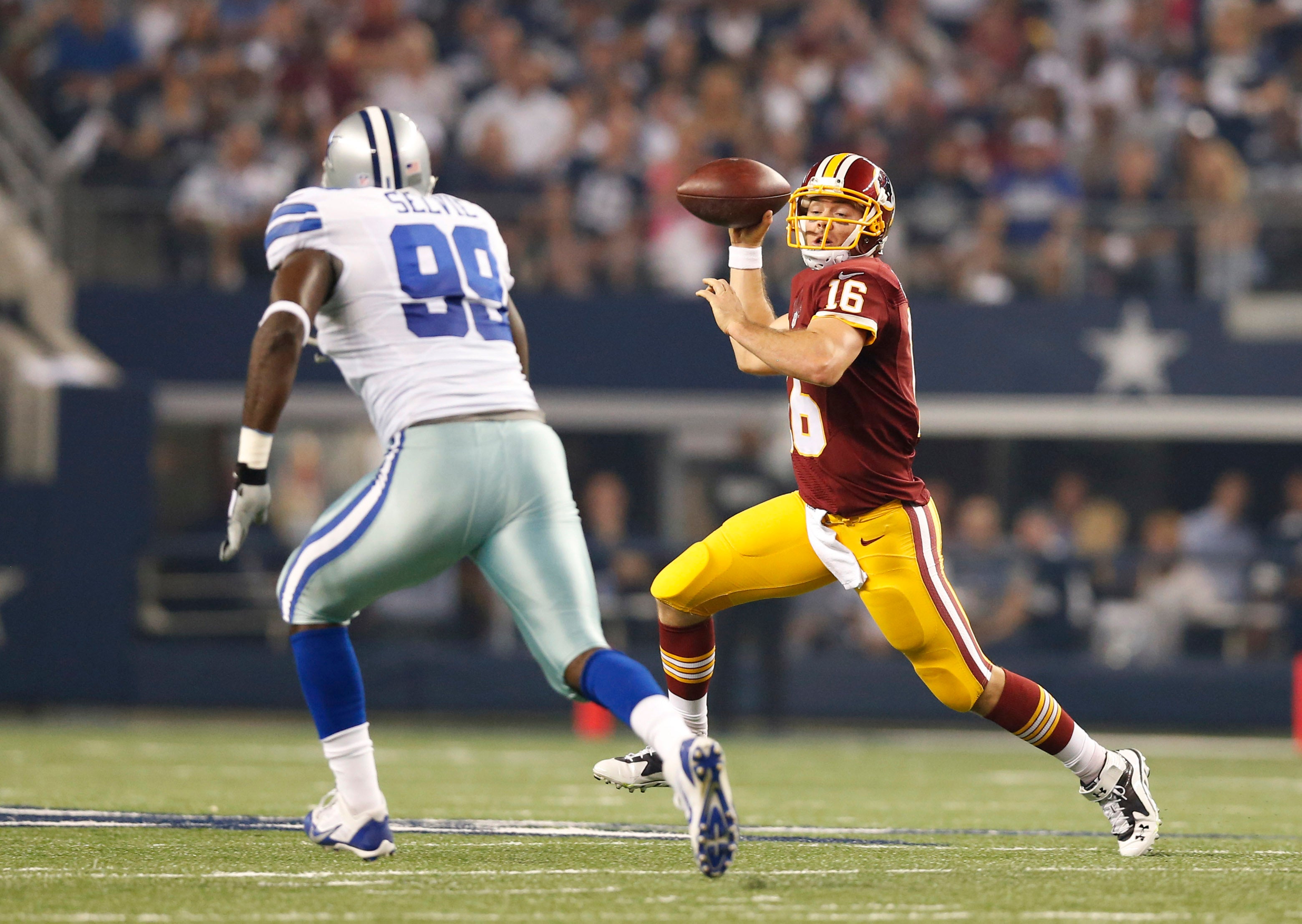 Oct 27, 2014; Arlington, TX, USA; Washington Redskins quarterback Colt McCoy (16)scrambles against Dallas Cowboys defensive end George Selvie (99) at AT&T Stadium.
