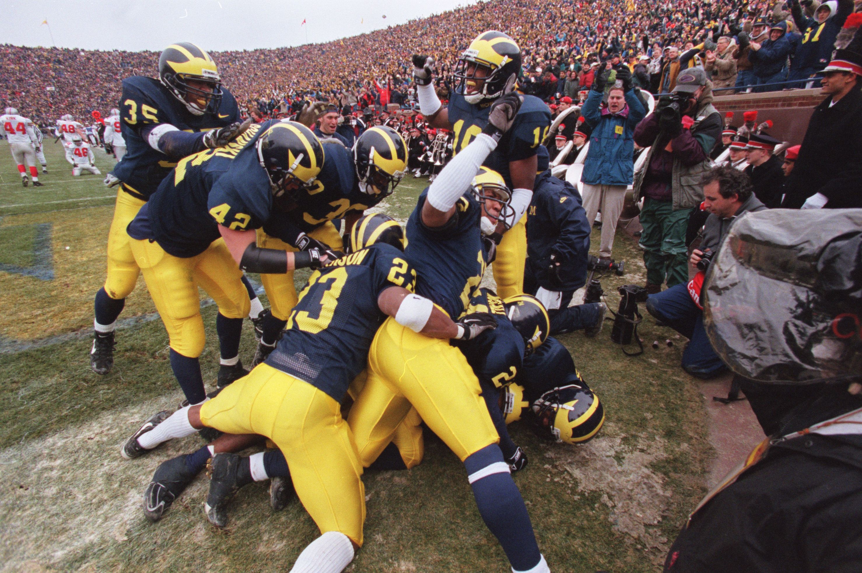 Michigan cornerback Charles Woodson is mobbed by celebrating teammates after his 2nd quarter punt return for a touchdown against Ohio State University on Saturday, Nov 22, at Michigan Stadium in Ann Arbor, MI. Um 112297 Endzone Pile Dpg