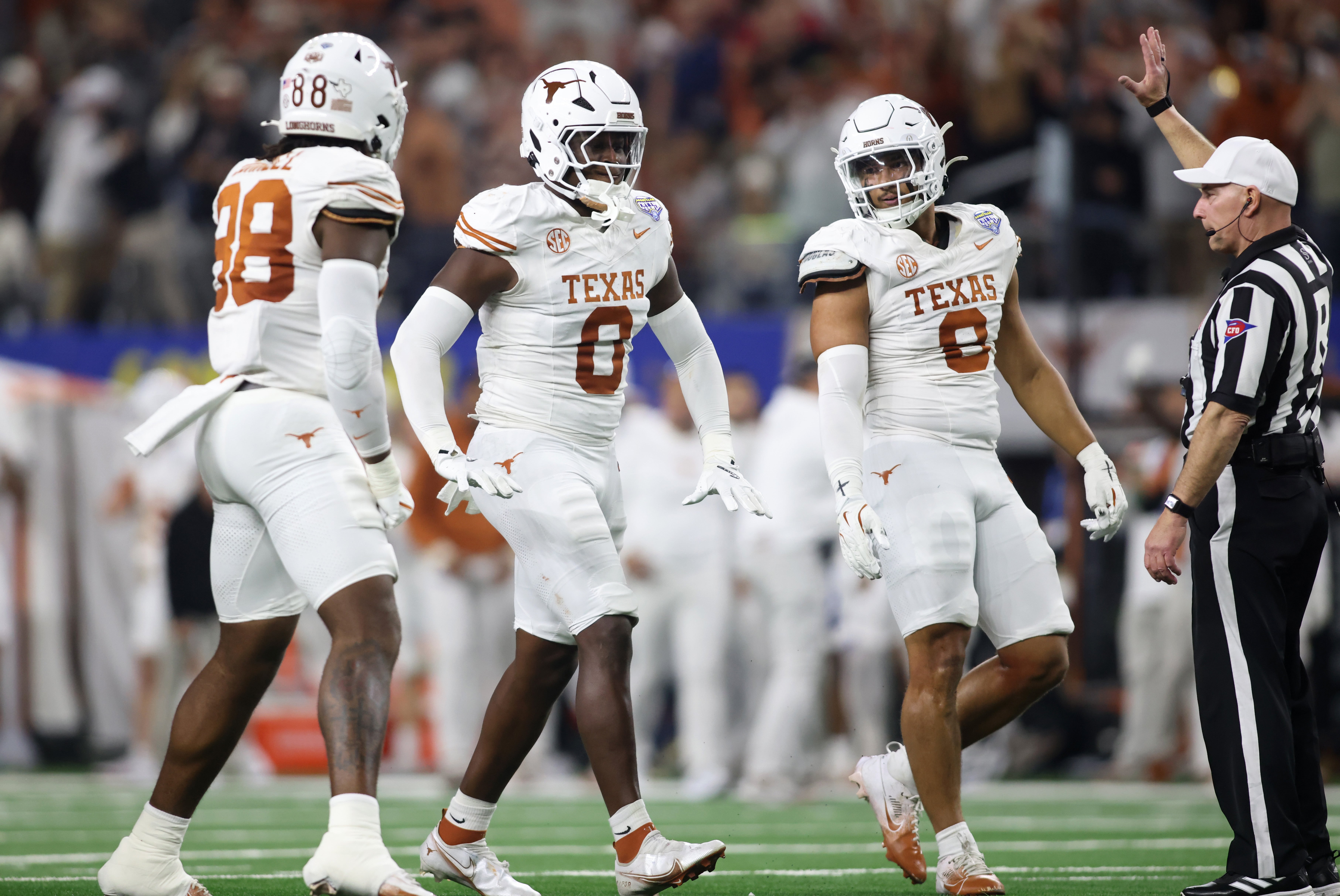 Jan 10, 2025; Arlington, Texas, USA; Texas Longhorns linebacker Anthony Hill Jr. (0) celebrates with linebacker Barryn Sorrell (88) and linebacker Trey Moore (8) after a play during the second quarter of the College Football Playoff semifinal against the Ohio State Buckeyes in the Cotton Bowl at AT&T Stadium.