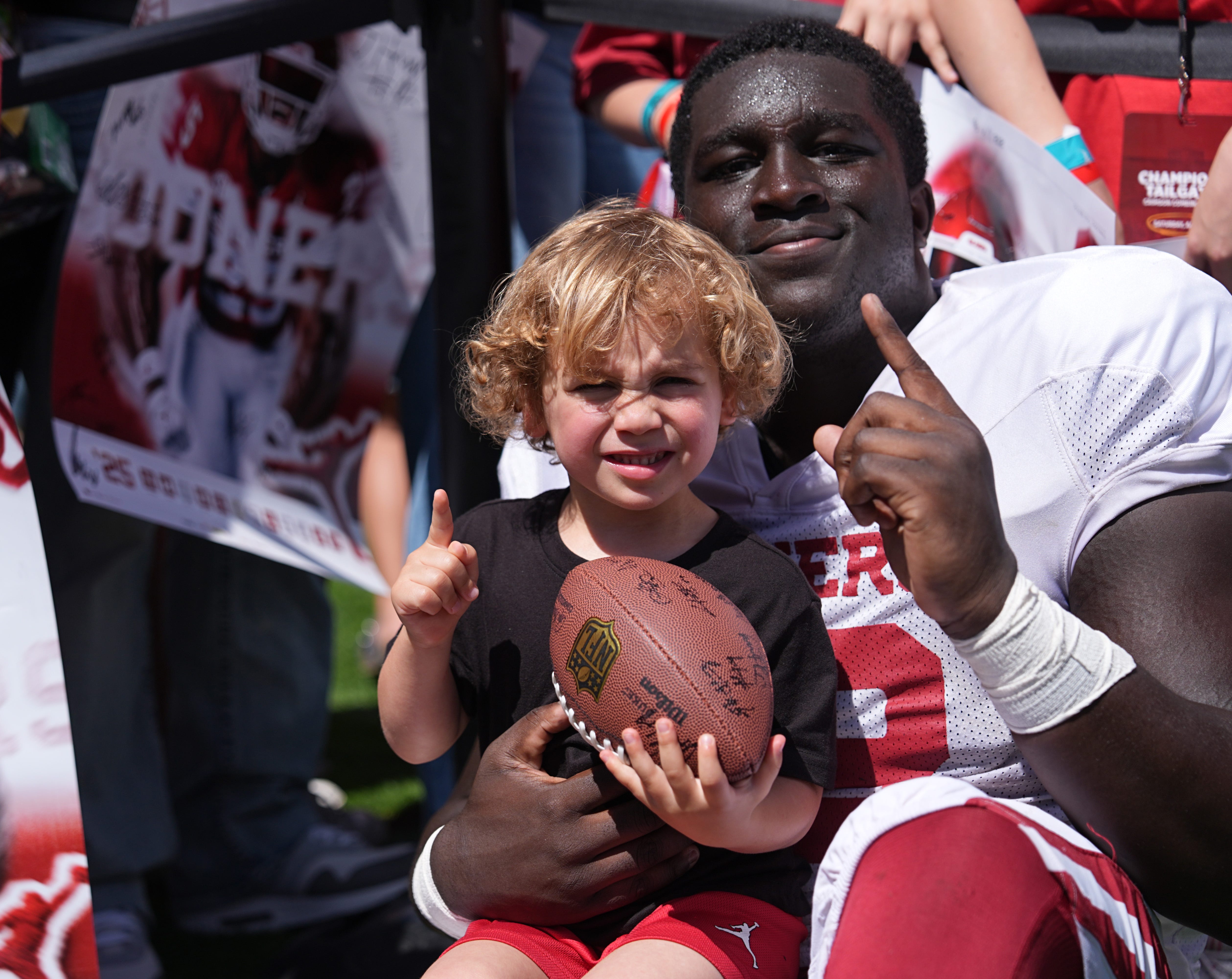 Oklahoma's Jacob Henry takes a picture with Easton Haak, 4, during the University of Oklahoma Sooners Crimson Combine at Gaylord Family - Oklahoma Memorial Stadium in Norman, Okla., Saturday, April, 12, 2025.