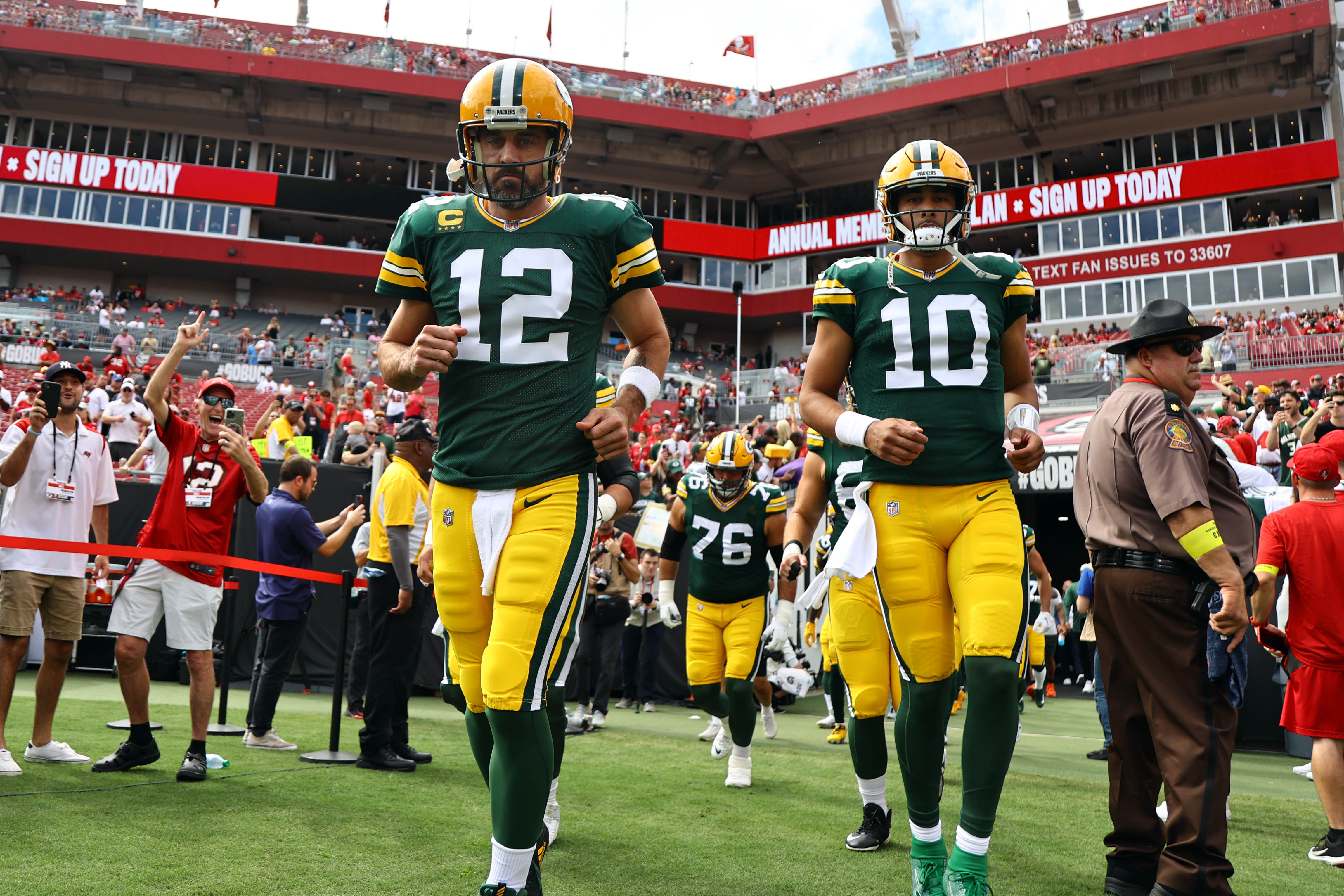 Green Bay Packers quarterbacks Aaron Rodgers (12) and Jordan Love (10) run out onto the field against the Tampa Bay Buccaneers at Raymond James Stadium. 