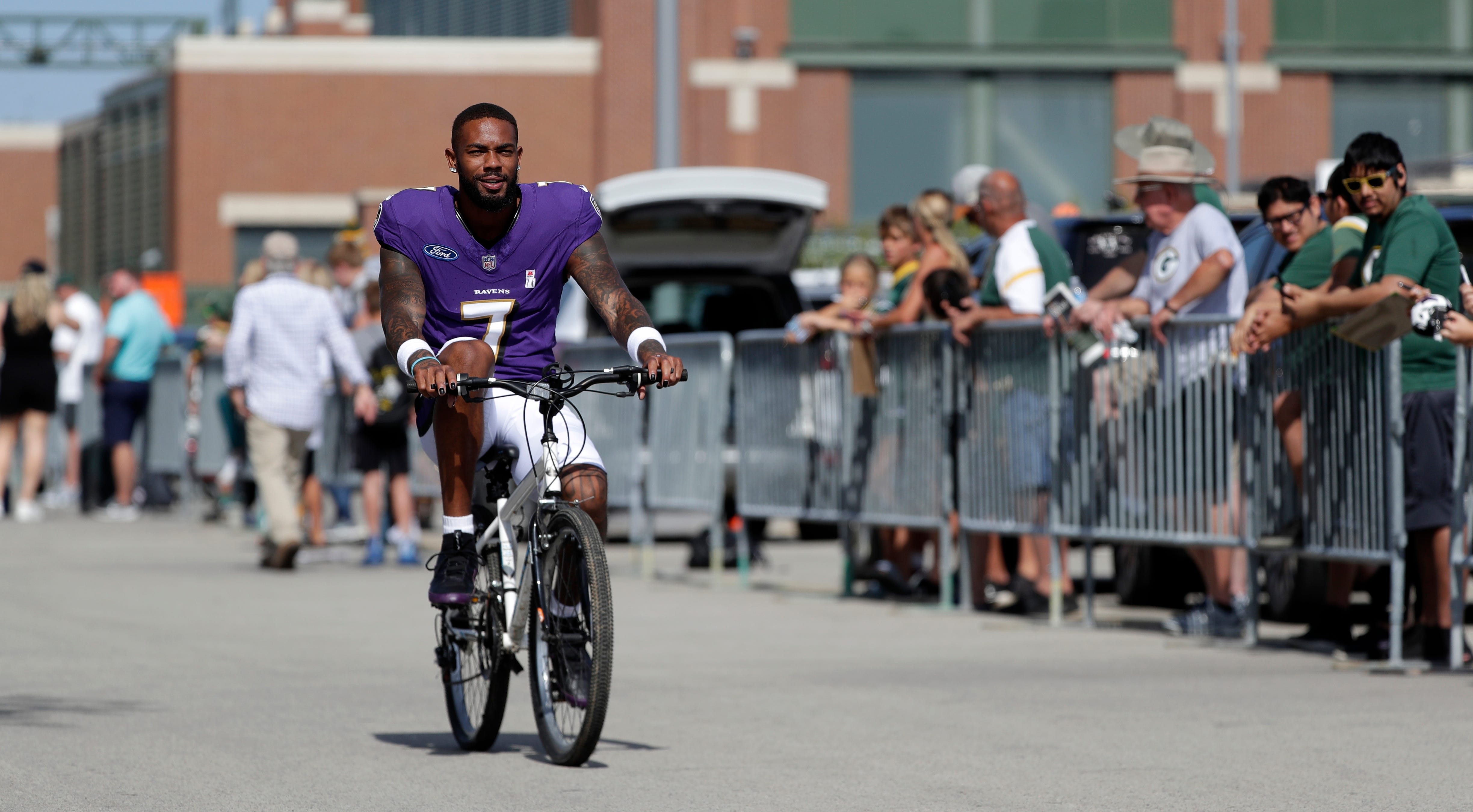 Baltimore Ravens wide receiver Rashod Bateman (7) rides a young fan's bicycle to a joint practice with the Green Bay Packers on Aug. 22, 2024 in Green Bay, Wis.