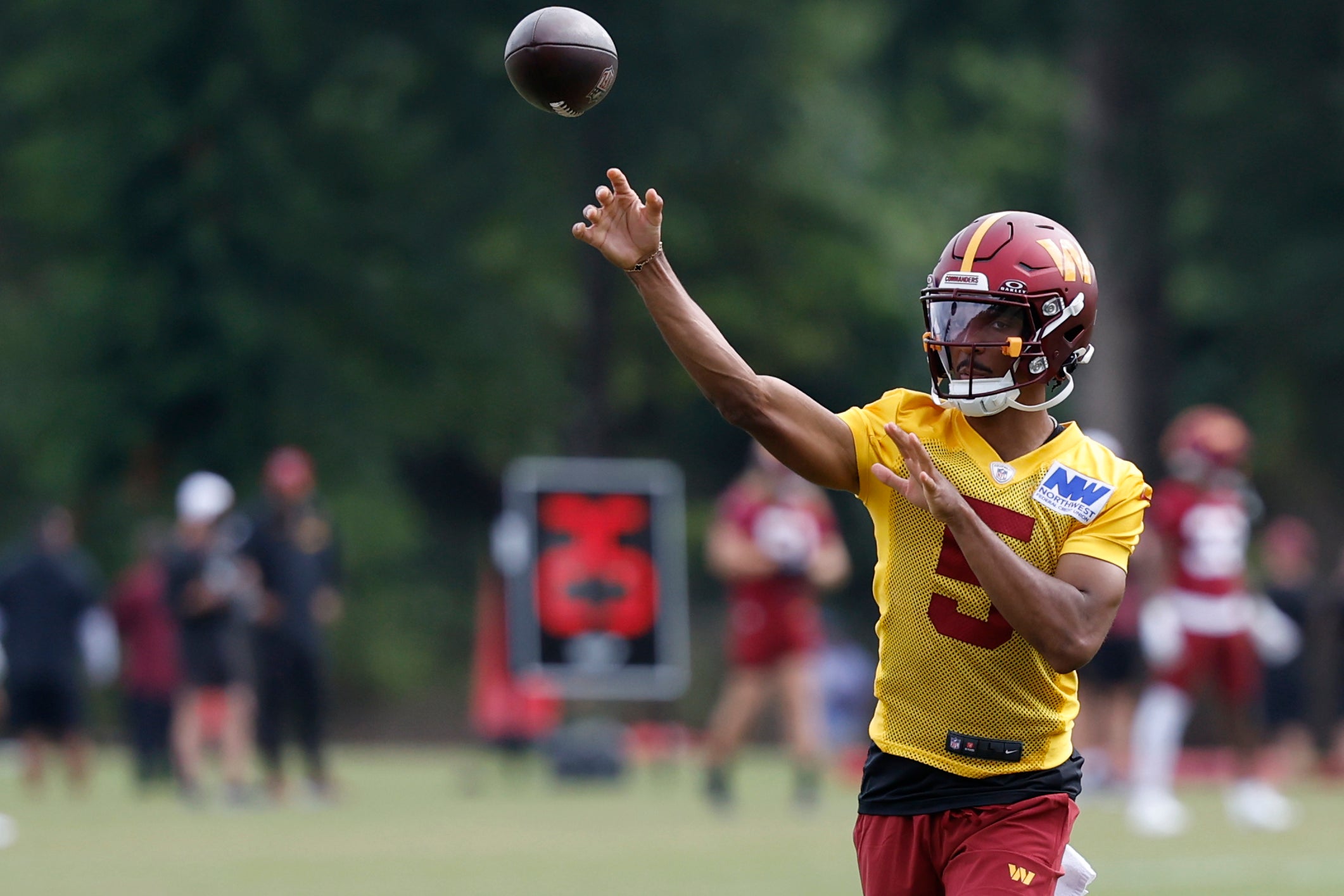 Jul 26, 2024; Ashburn, VA, USA; Washington Commanders quarterback Jayden Daniels (5) passes the ball on day three of training camp at Commanders Park.