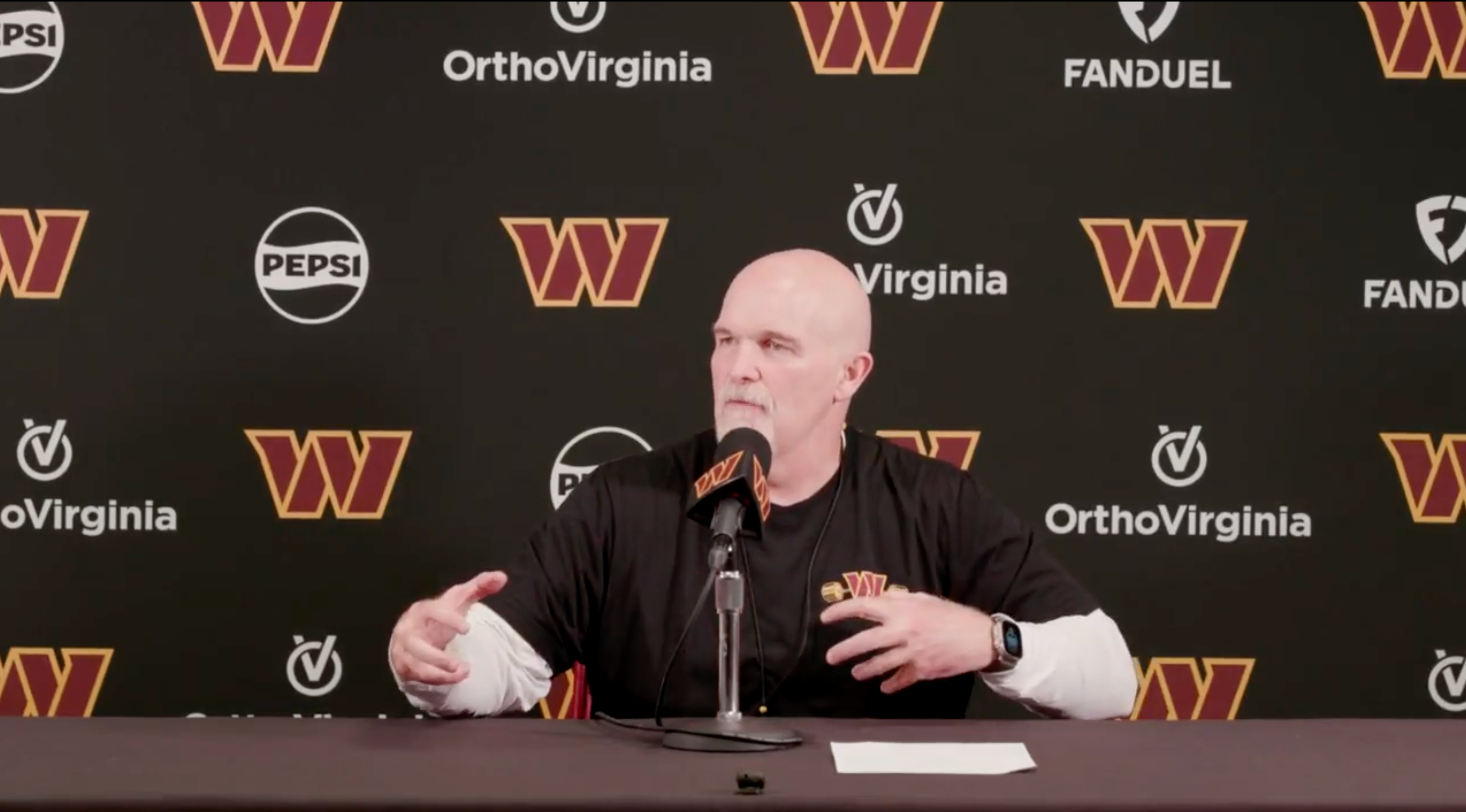 Dan Quinn talks with reporters during Commanders mandatory minicamp.