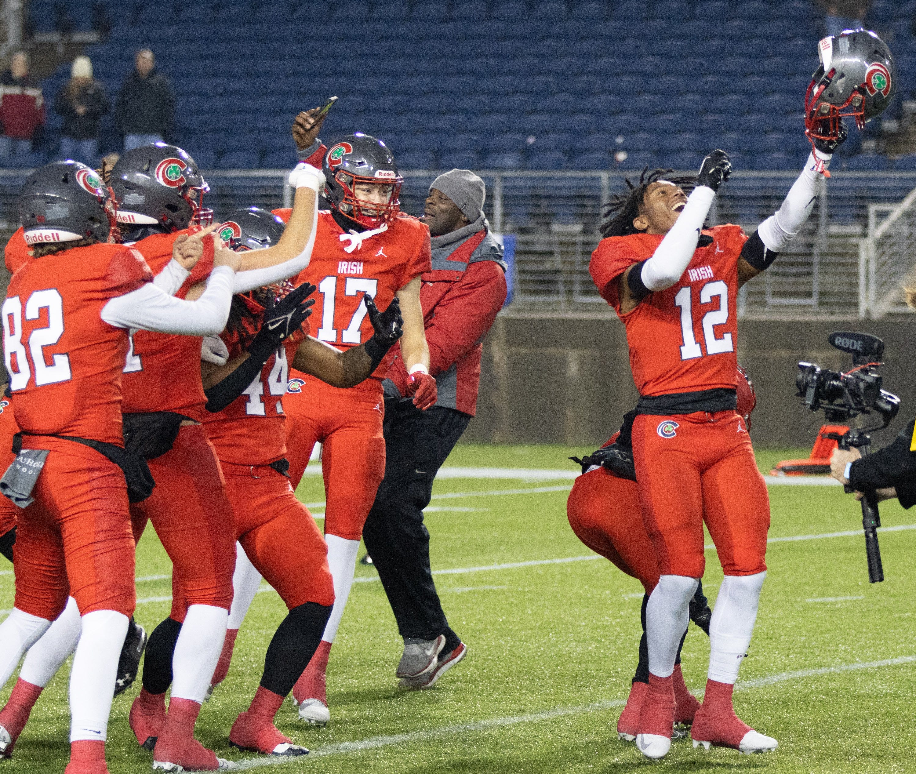 Toledo Central Catholic s Preston Fryzel (17), D Haron Flowers (12) and teammates celebrate their victory over Bishop Watterson in the Division III state final Friday, Dec. 1, 2023, in Canton.