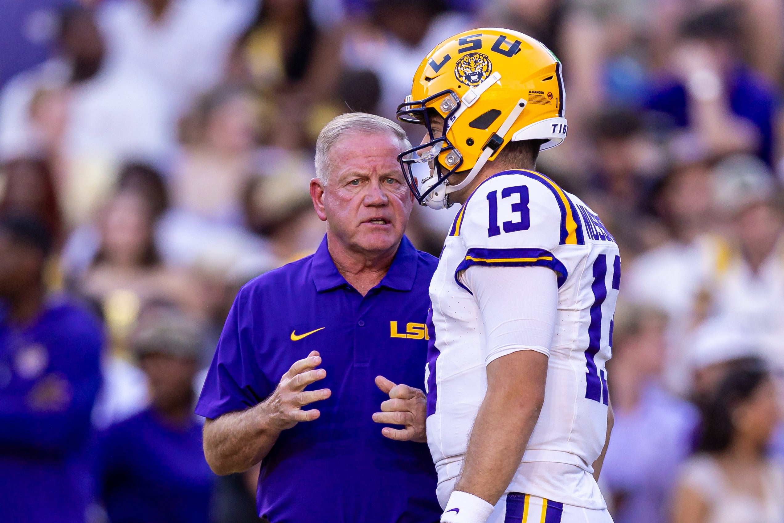 Sep 28, 2024; Baton Rouge, Louisiana, USA; LSU Tigers quarterback Garrett Nussmeier (13) talks to head coach Brian Kelly during warmups before a game against the South Alabama Jaguars at Tiger Stadium.