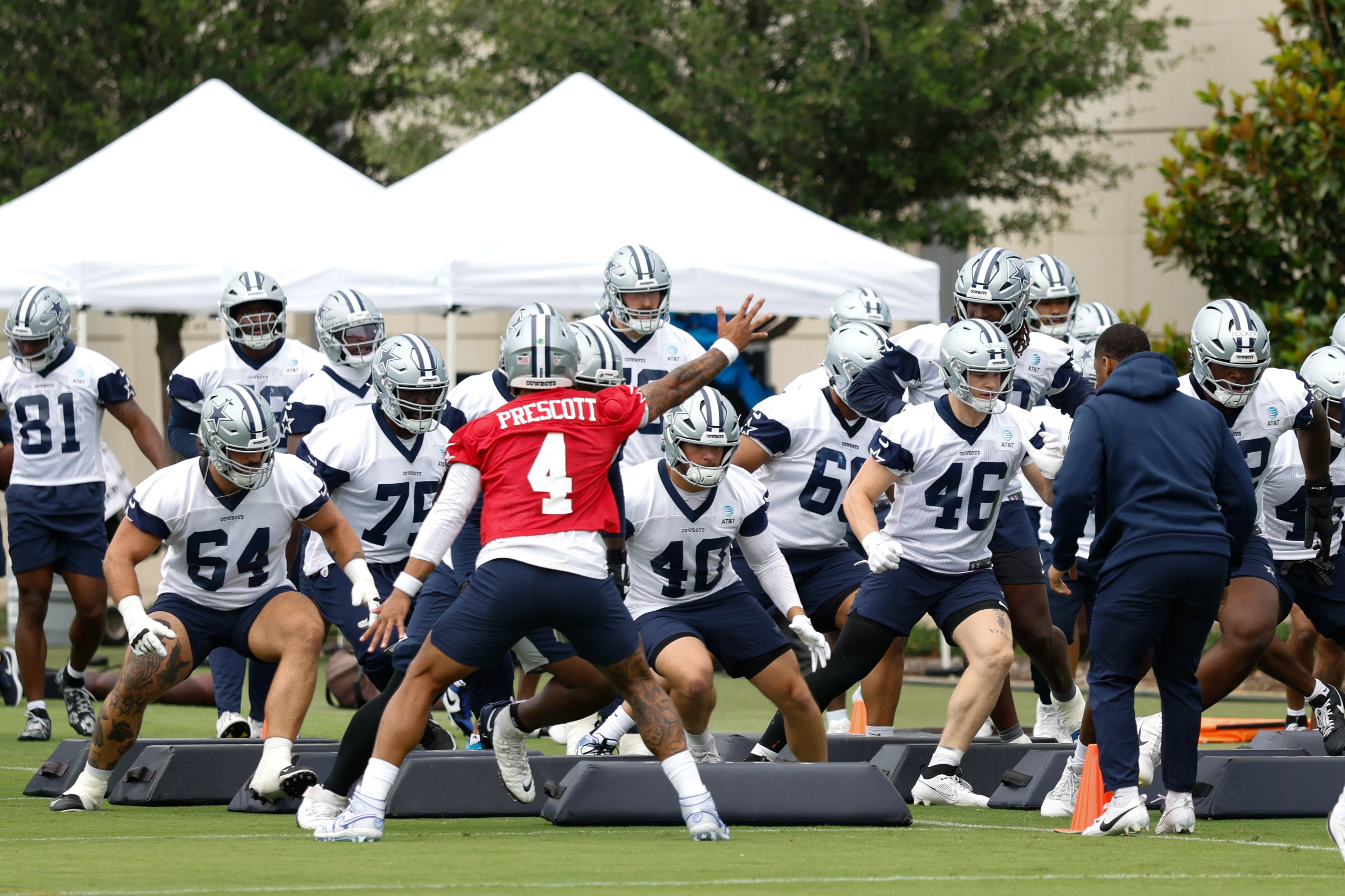 Dallas Cowboys quarterback Dak Prescott (4) leads teammates through a drill at the Ford Center at the Star Training Facility in Frisco, Texas.