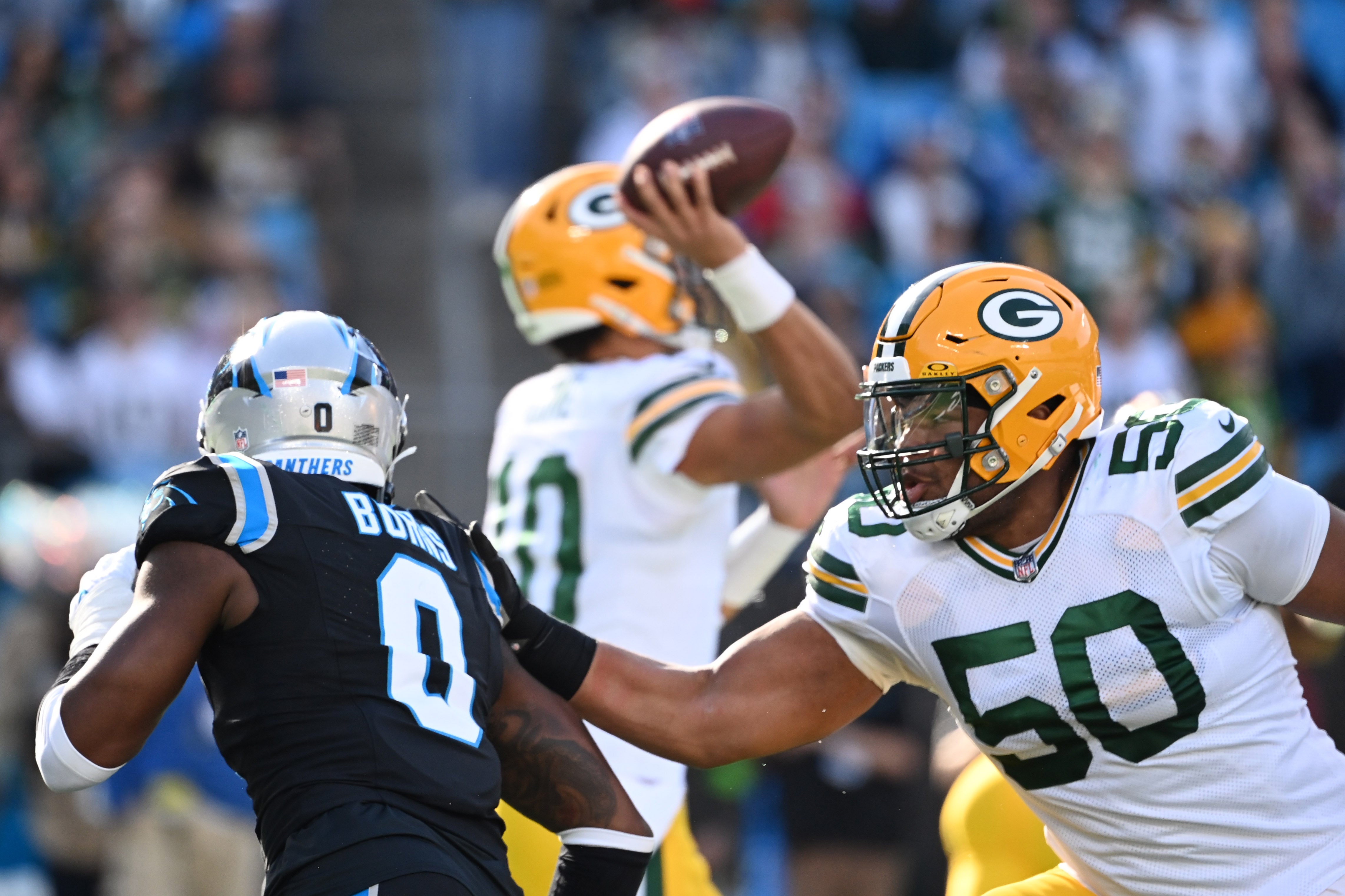 Green Bay Packers guard Zach Tom (50) blocks Carolina Panthers linebacker Brian Burns (0) as quarterback Jordan Love (10) attempts to pass in the second quarter at Bank of America Stadium.