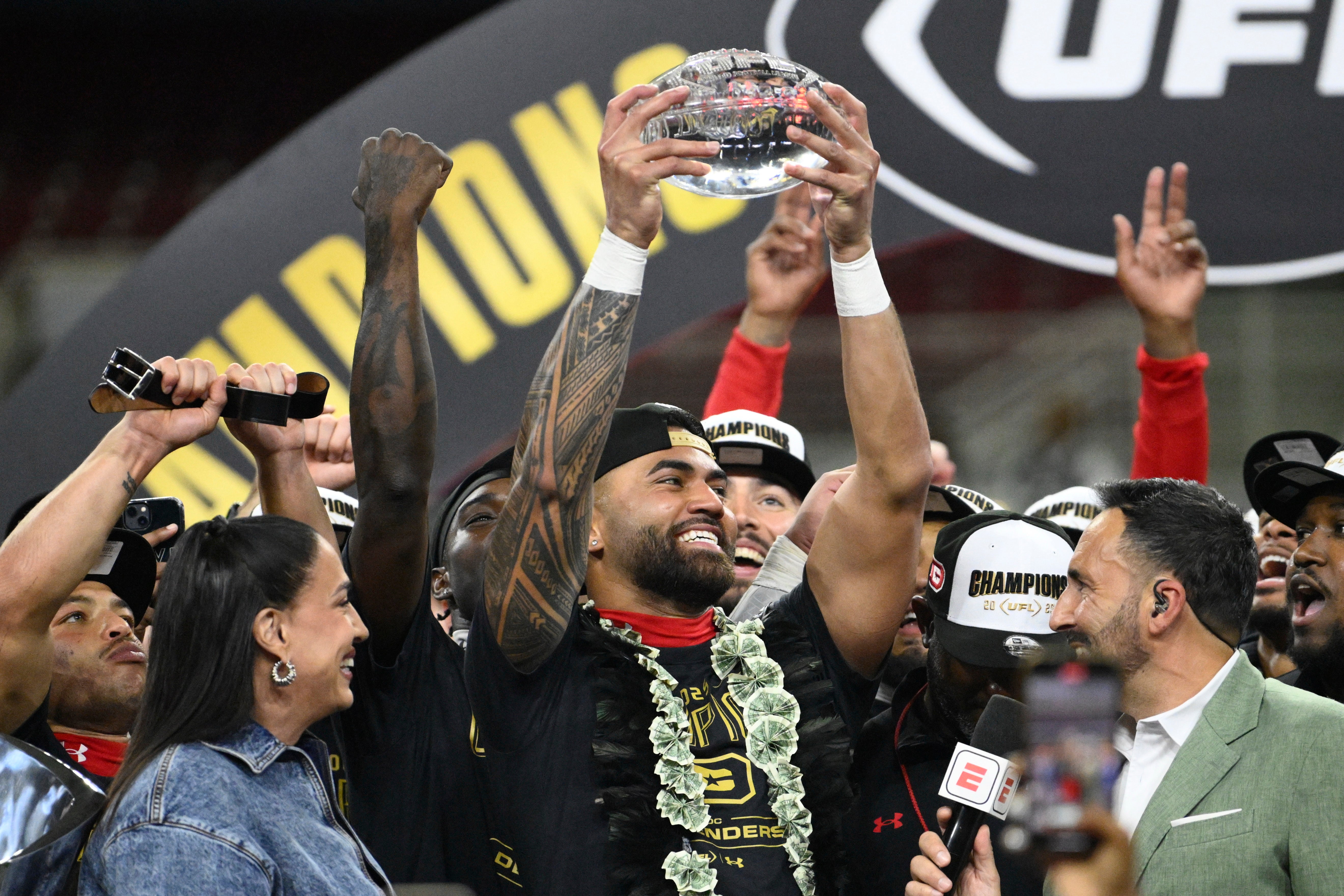 Jun 14, 2025; St. Louis, MO, USA; DC Defenders quarterback Jordan Ta'amu raises the UFL Championship MVP trophy after defeating the Michigan Panthers in the 2025 UFL Championship game at The Dome at America’s Center.