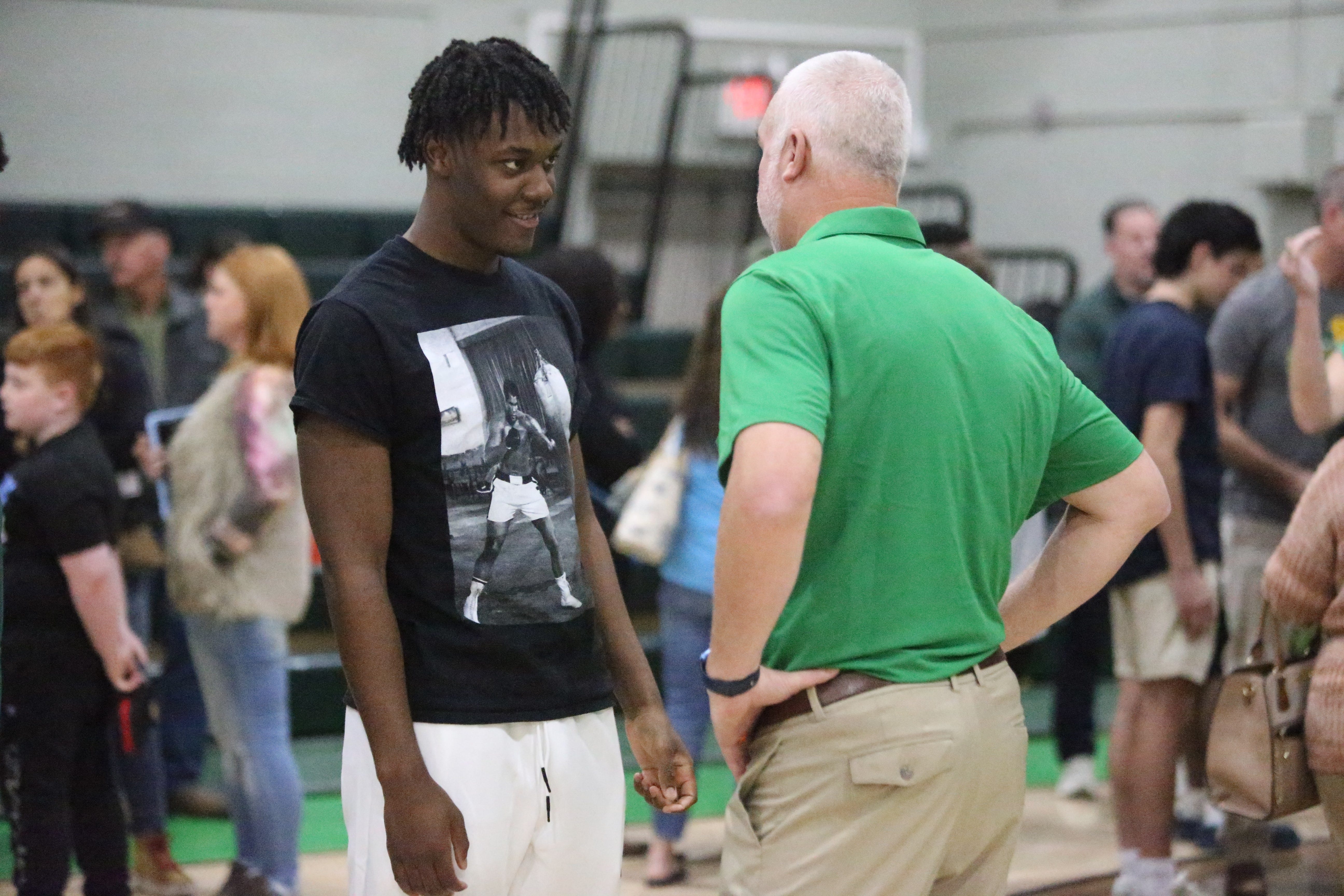 New Pensacola Catholic head football coach Bobby Clayton (right) speaks with Pensacola Catholic EDGE rusher Trenton Henderson (left) during a formal introduction on Sunday, Jan. 5, 2024.