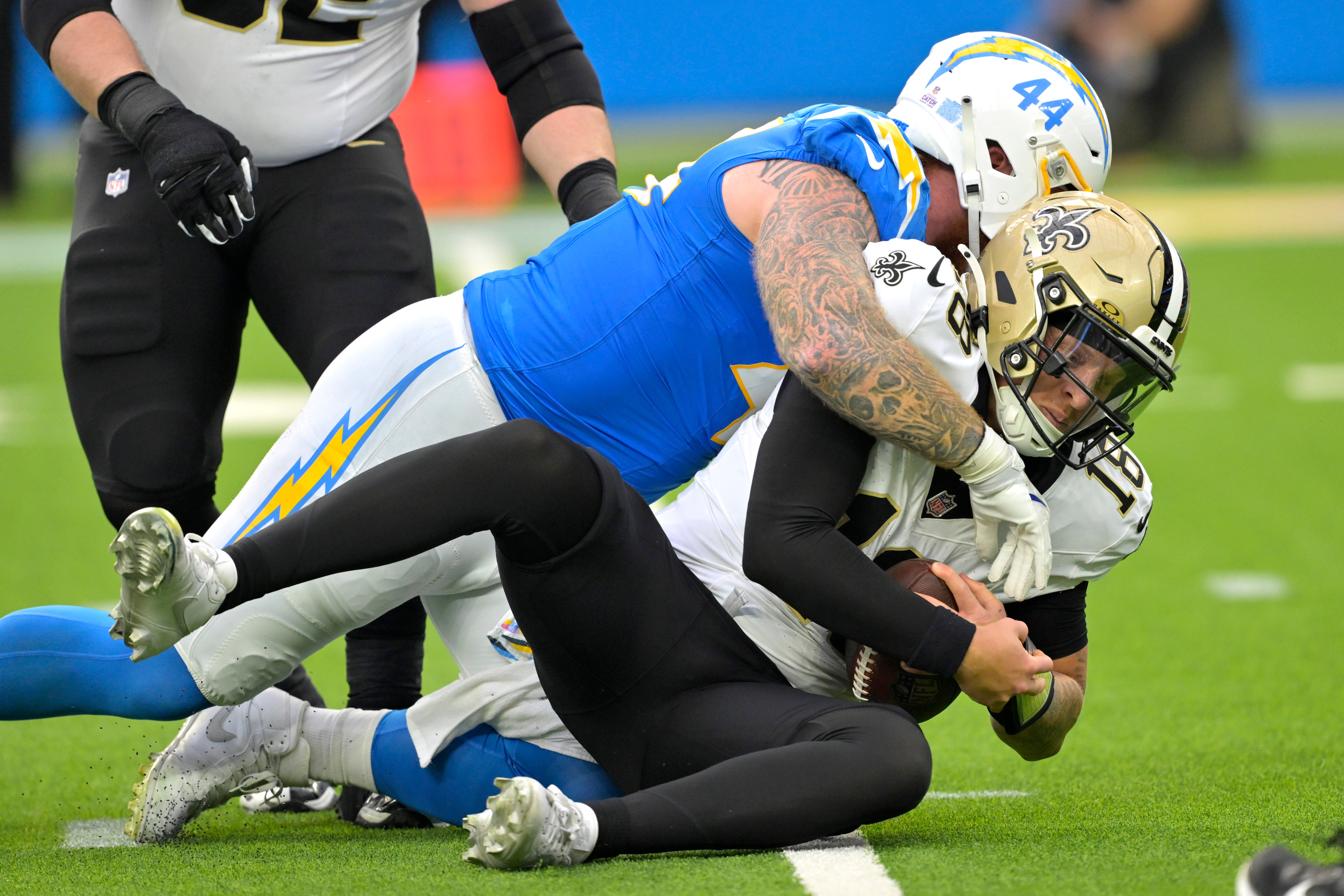 New Orleans Saints quarterback Spencer Rattler (18) is sacked by Los Angeles Chargers defensive tackle Scott Matlock (44)