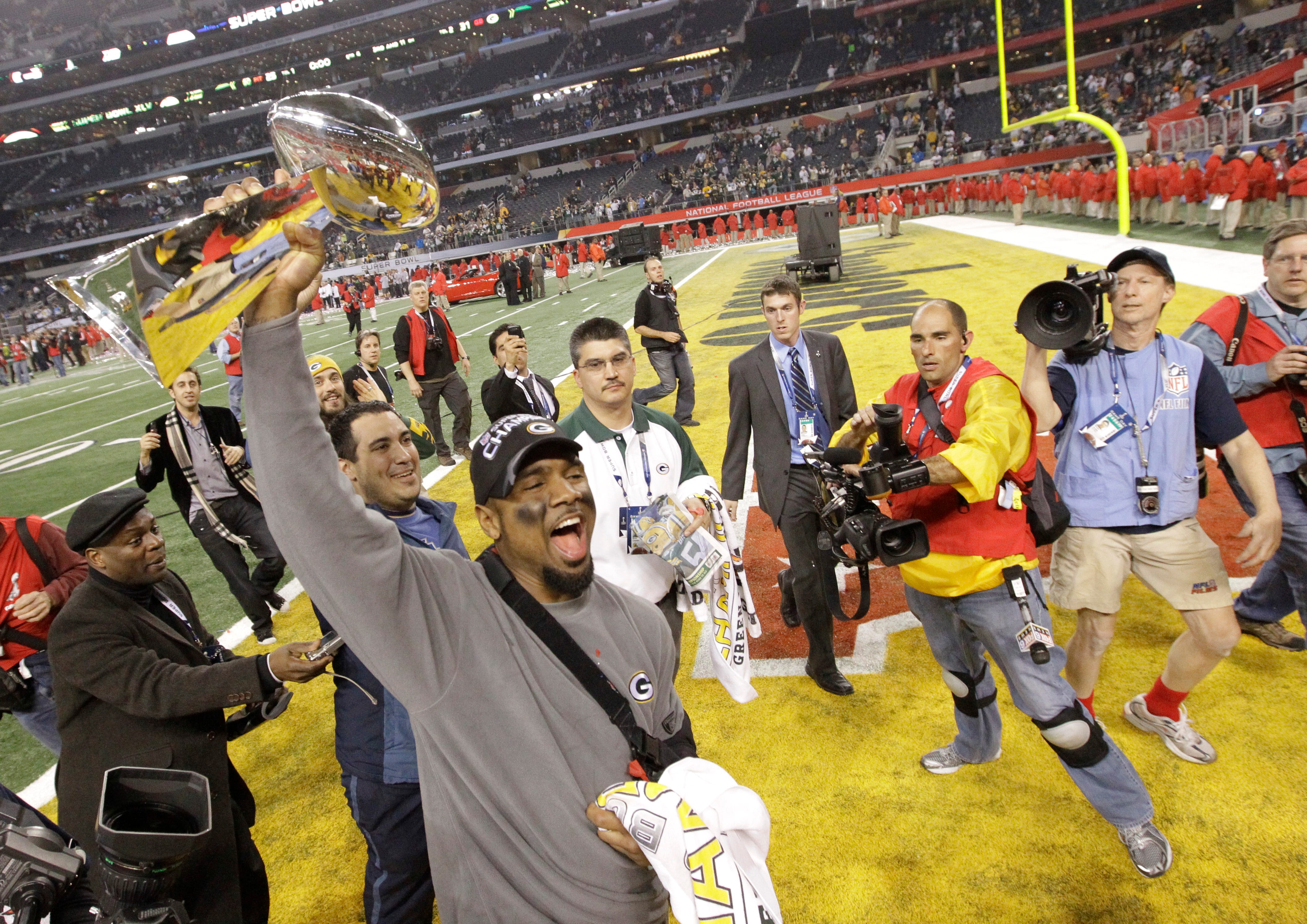 Green Bay Packers cornerback Charles Woodson carries the Vince Lombardi Trophy following their win over the Pittsburgh Steelers in Super Bowl XLV, in Arlington, Texas, Sunday, February 6, 2011.
