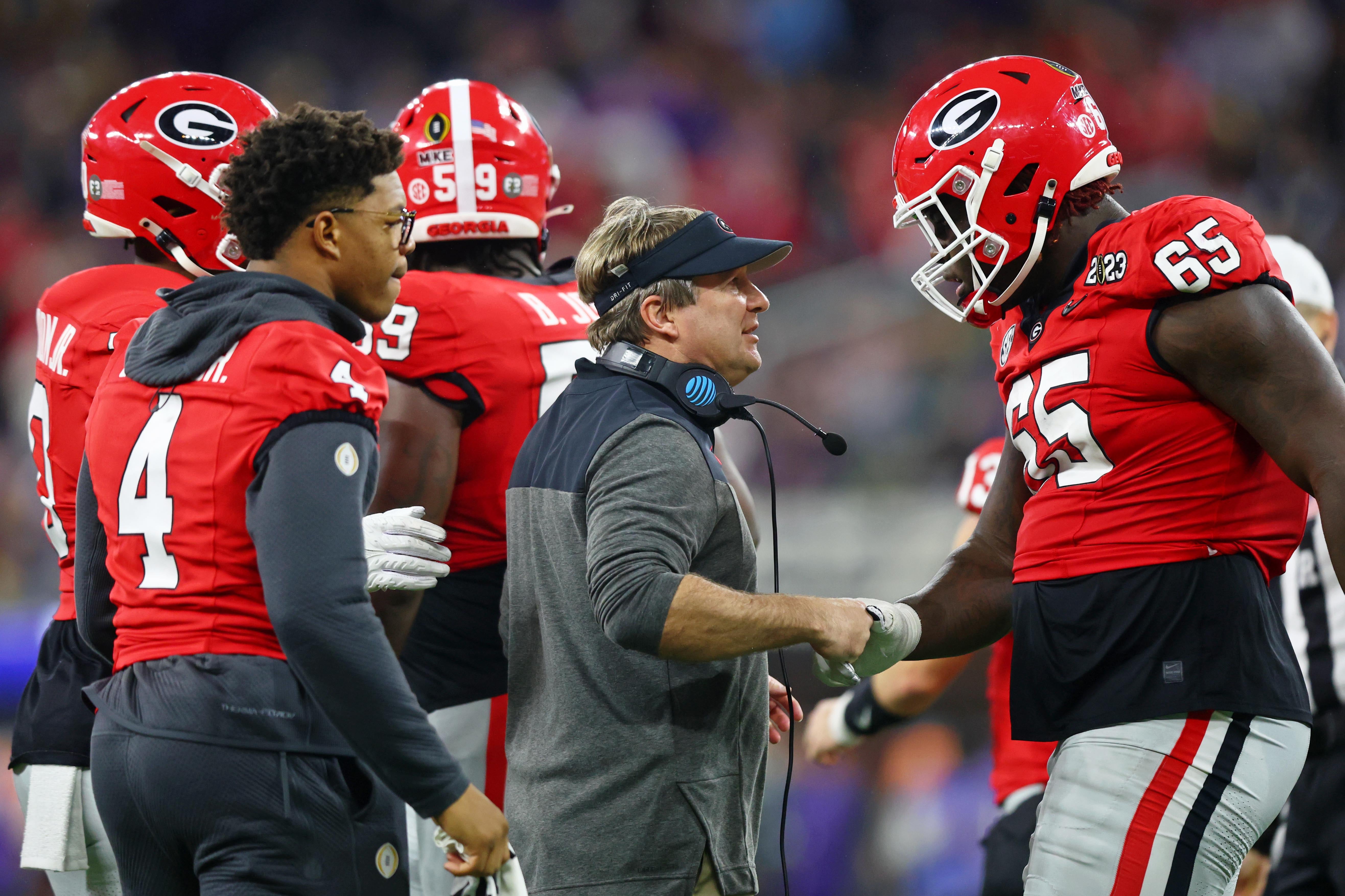 Kirby Smart talks with offensive tackle Amarius Mims on the sideline for the Georgia Bulldogs