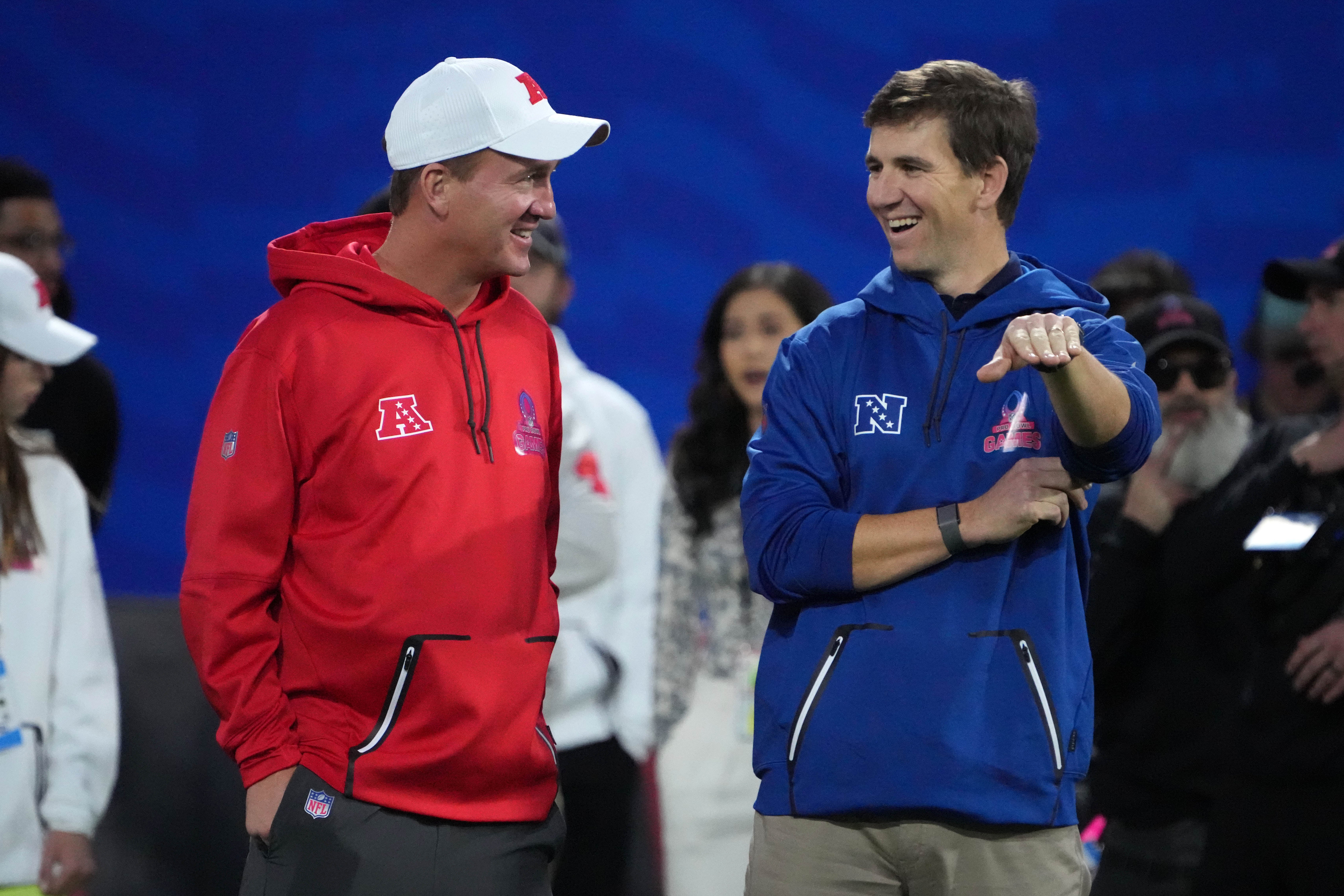 Feb 2, 2023; Henderson, NV, USA; Peyton Manning (left) and Eli Manning react during the Pro Bowl Skills competition at the Intermountain Healthcare Performance Facility.