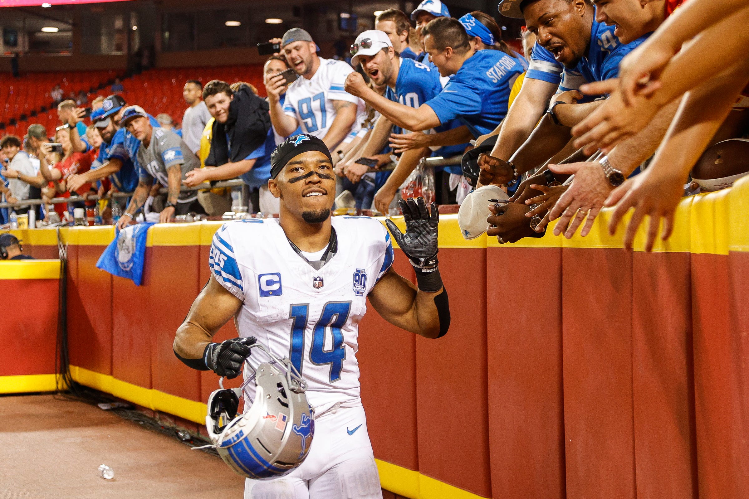 Detroit Lions wide receiver Amon-Ra St. Brown (14) high fives fans after 21-20 win over Kansas City Chiefs at Arrowhead Stadium