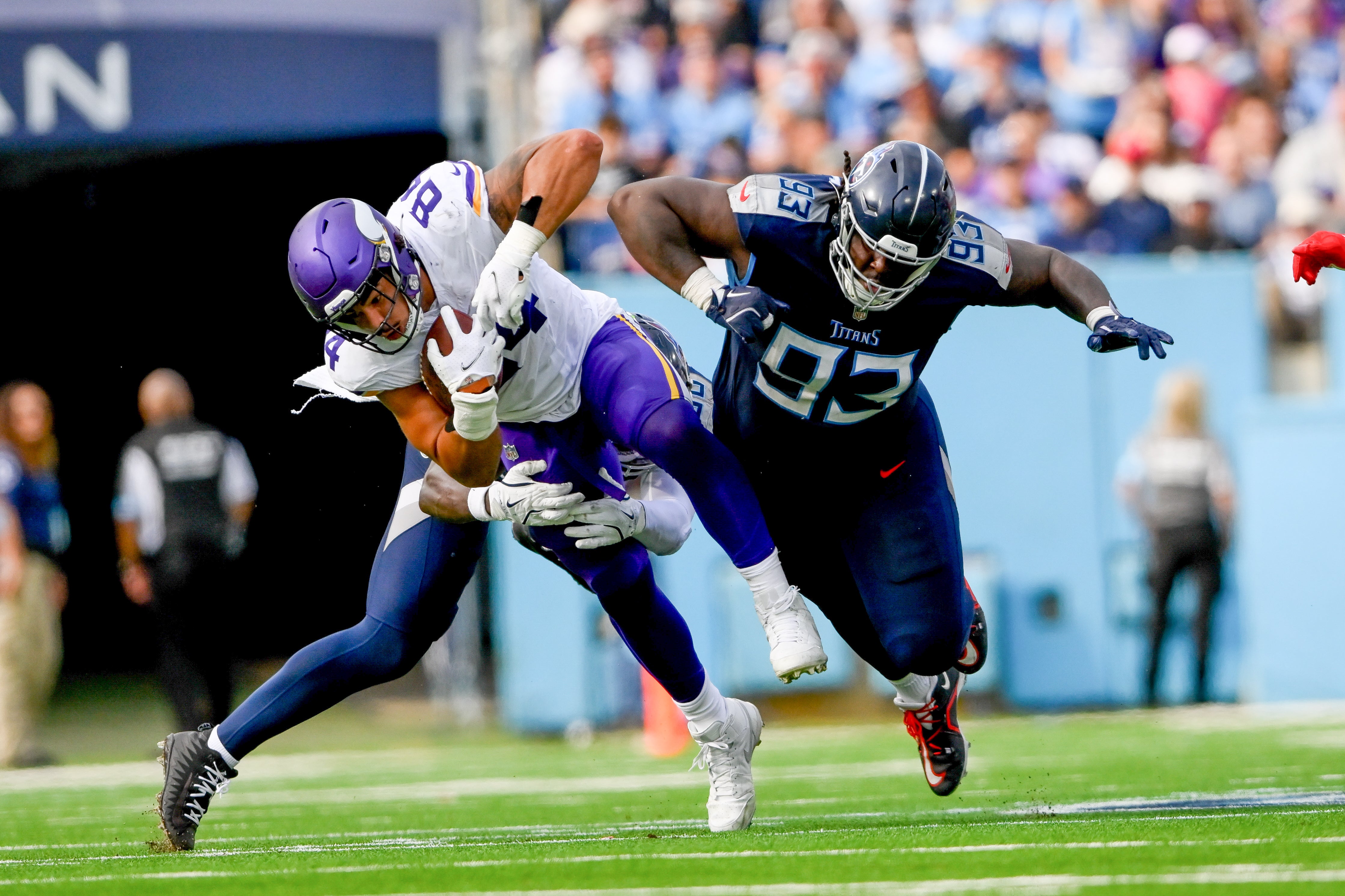 Nov 17, 2024; Nashville, Tennessee, USA; Tennessee Titans running back Julius Chestnut (36) and defensive tackle T'Vondre Sweat (93) tackle Minnesota Vikings tight end Josh Oliver (84) during the first half at Nissan Stadium.