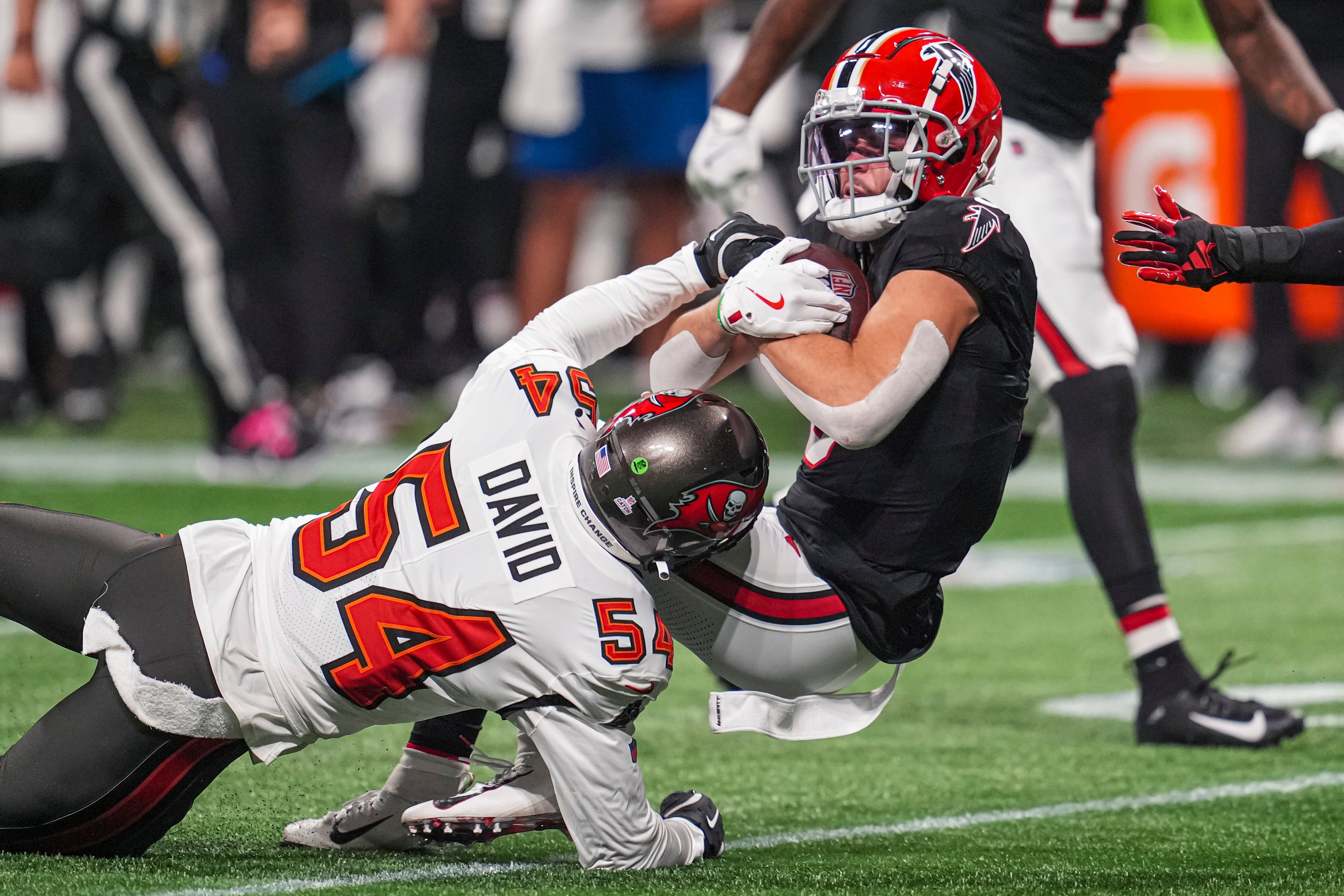 Oct 3, 2024; Atlanta, Georgia, USA; Atlanta Falcons wide receiver Drake London (5) is tackled by Tampa Bay Buccaneers linebacker Lavonte David (54) during the first quarter at Mercedes-Benz Stadium.