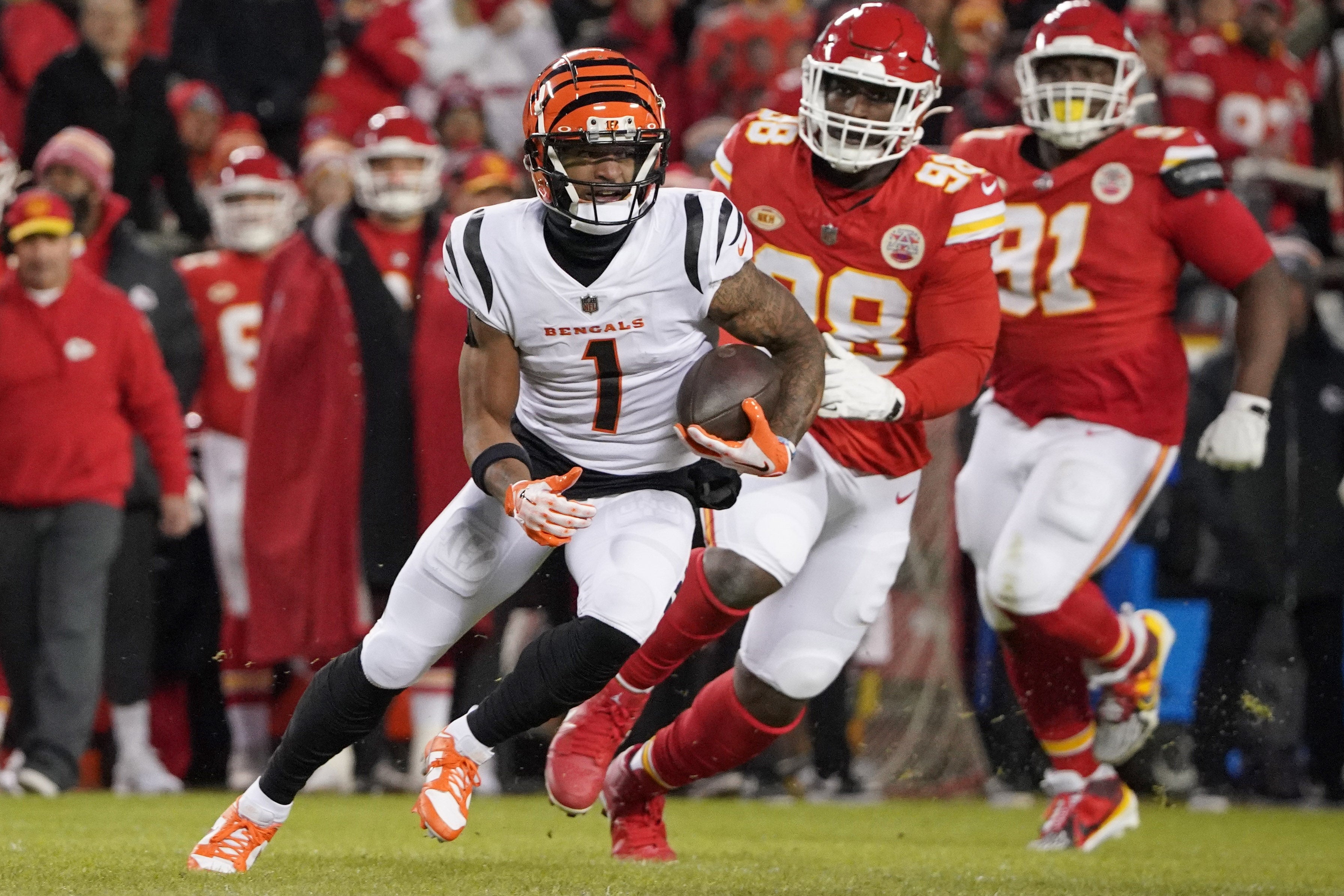 Dec 31, 2023; Kansas City, Missouri, USA; Cincinnati Bengals wide receiver Ja'Marr Chase (1) runs the ball as Kansas City Chiefs defensive tackle Tershawn Wharton (98) chases during the game at GEHA Field at Arrowhead Stadium.