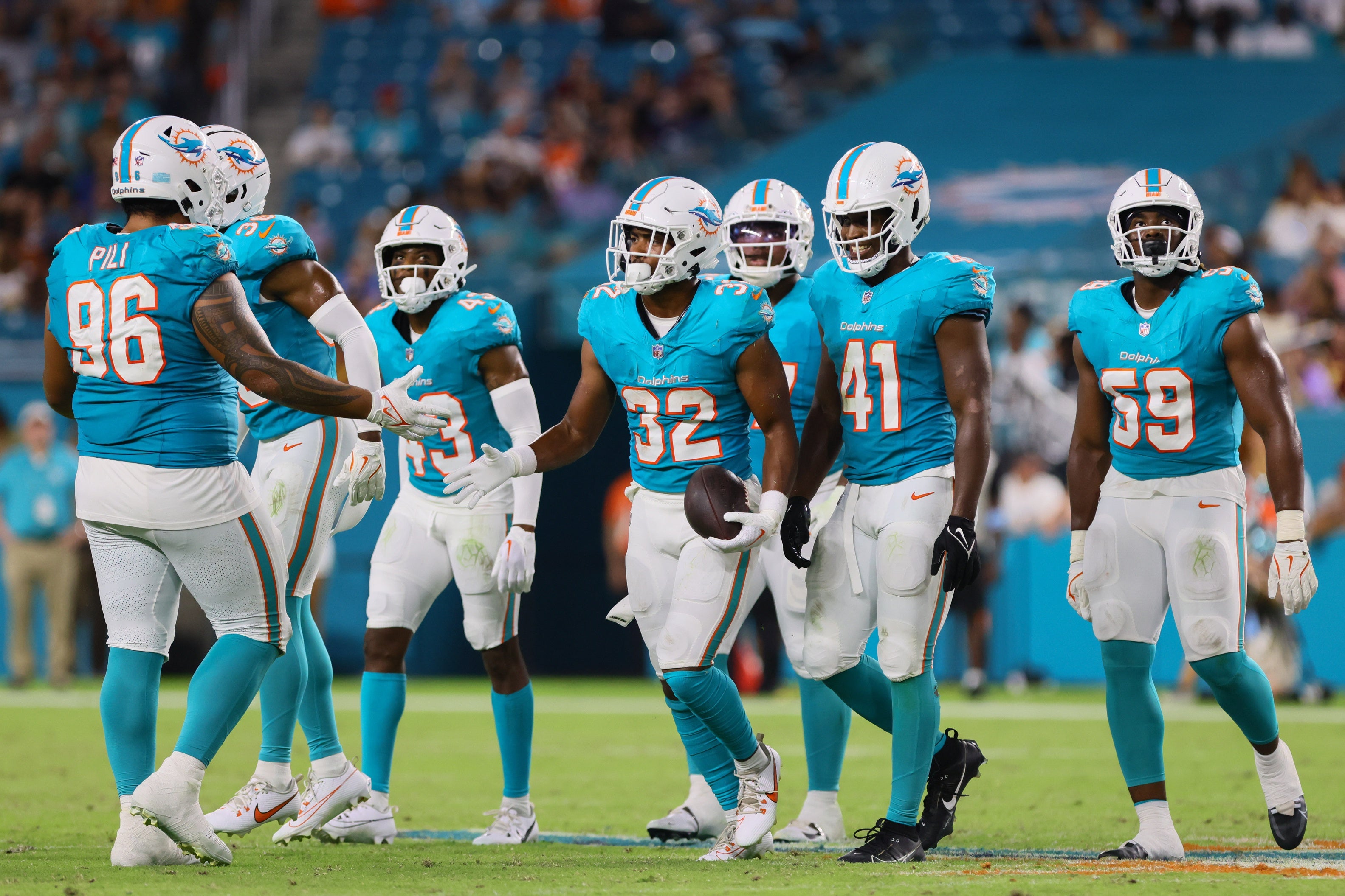 Miami Dolphins safety Patrick McMorris (32) celebrates with teammates after recovering a fumble against the Washington Commanders during the fourth quarter of a preseason game at Hard Rock Stadium.