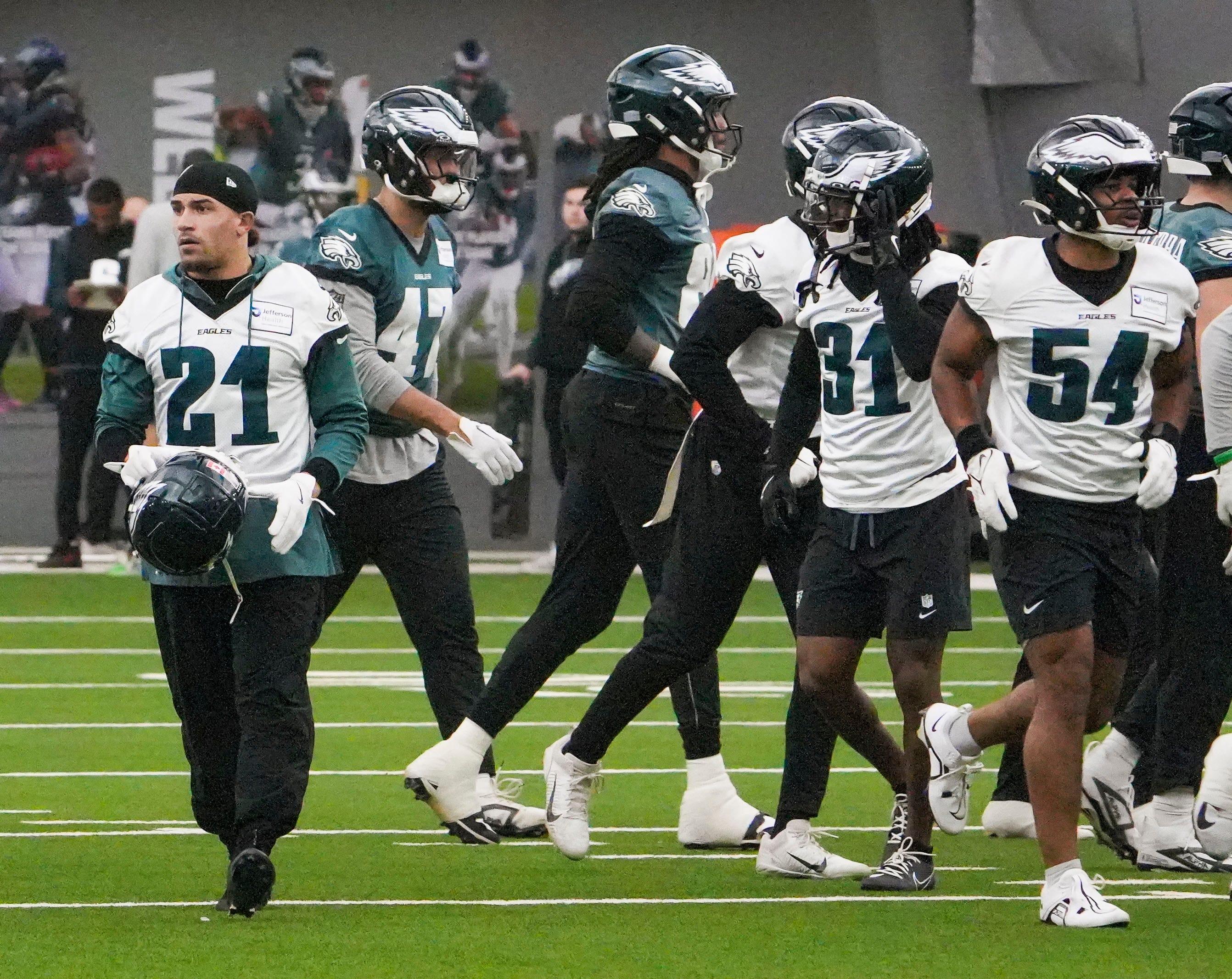 Eagles safety Sydney Brown (21) and linebacker Jeremiah Trotter Jr. (54) join other members of the defense as the Philadelphia Eagles work out in preparation for the Super Bowl at the NovaCare Complex.