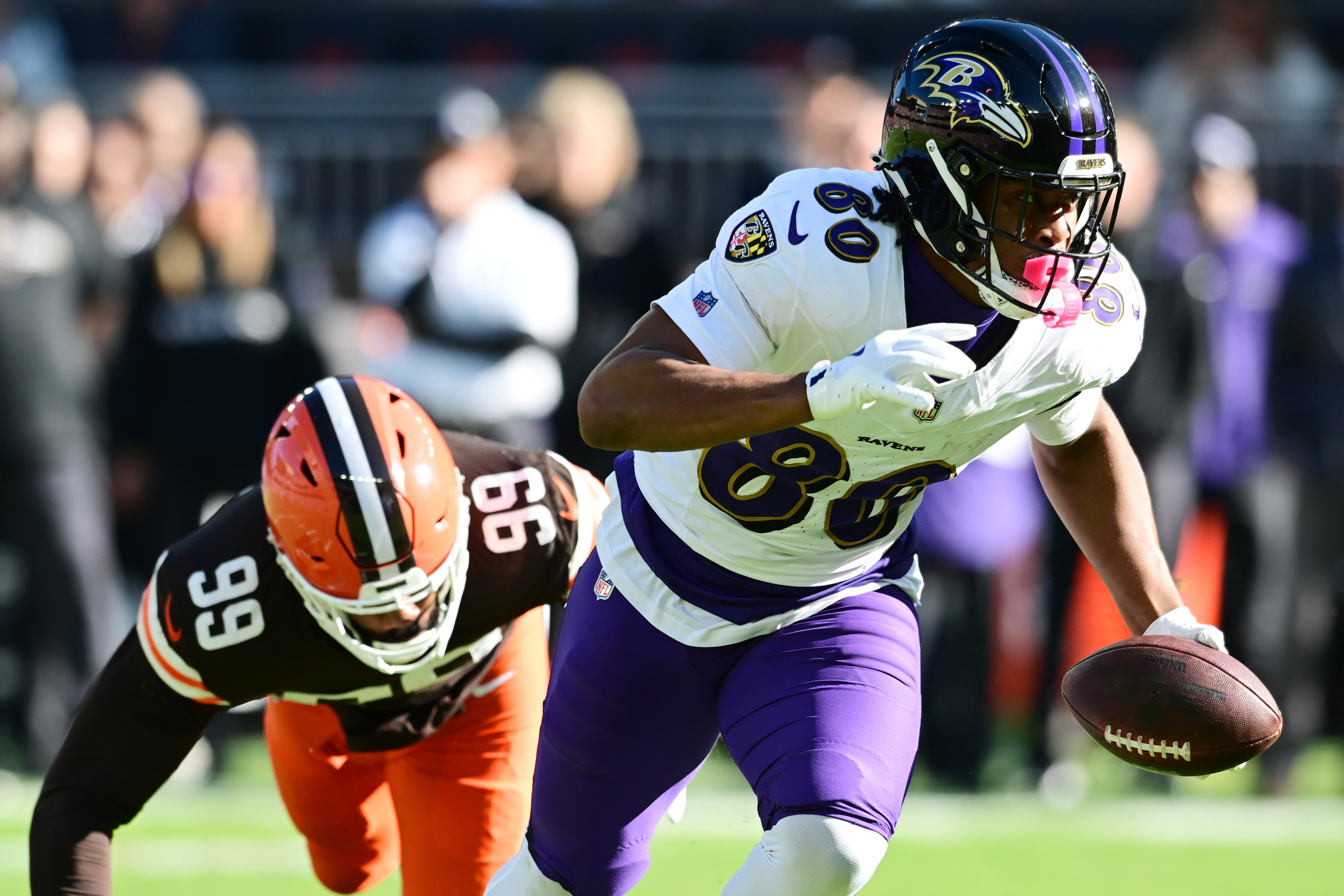 Oct 27, 2024; Cleveland, Ohio, USA; Baltimore Ravens tight end Isaiah Likely (80) runs with the ball after a catch as Cleveland Browns safety Rodney McLeod Jr. (12) defends during the second half at Huntington Bank Field.