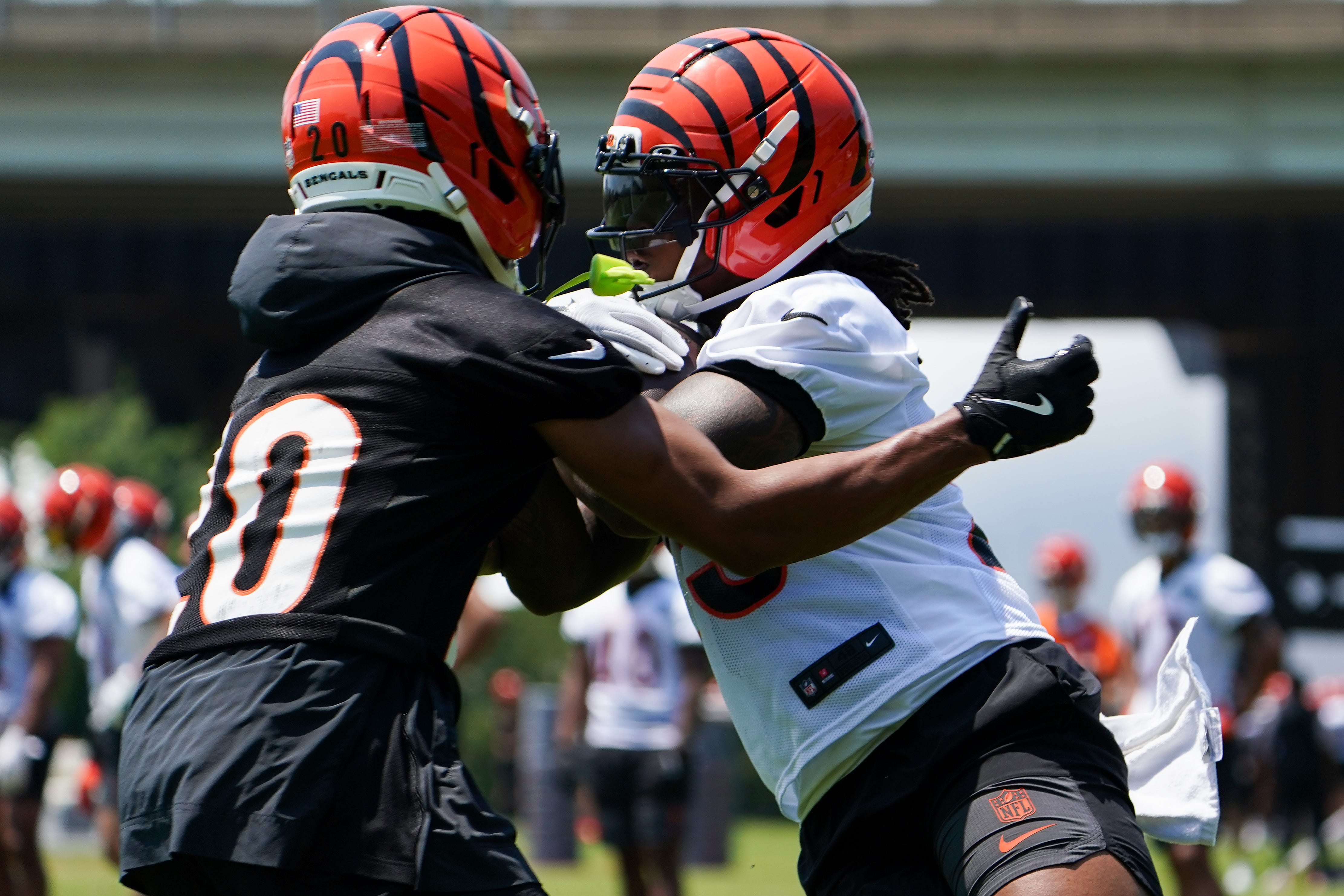 Cincinnati Bengals cornerback DJ Turner II (20) and running back Tahj Brooks (25) participate in a scrimmage, Wednesday, June 11, 2025, at Kettering Health Practice Fields in Downtown Cincinnati.