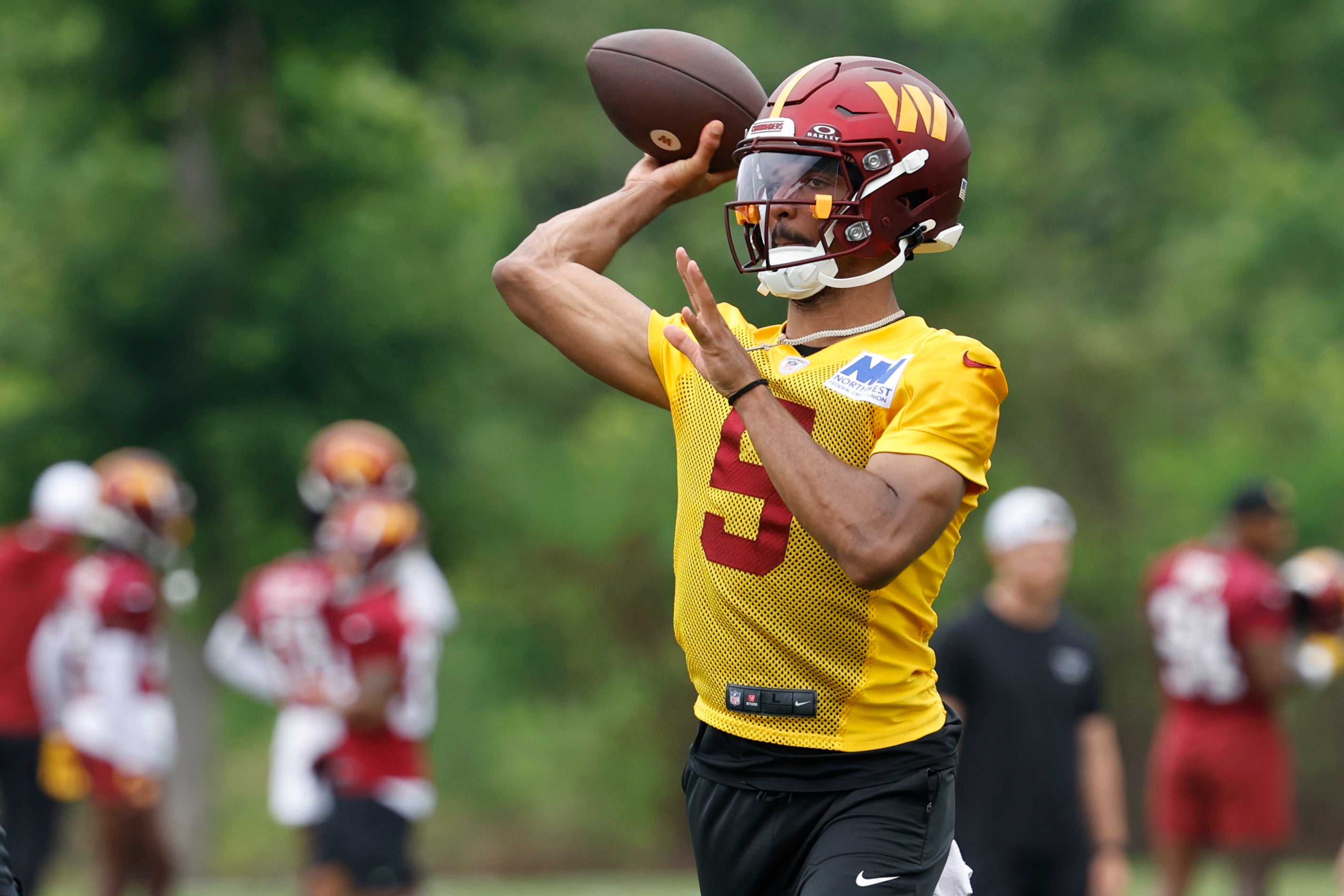 Jun 5, 2024; Ashburn, VA, USA; Washington Commanders quarterback Jayden Daniels (5) passes a ball during an OTA workout at Commanders Park. 