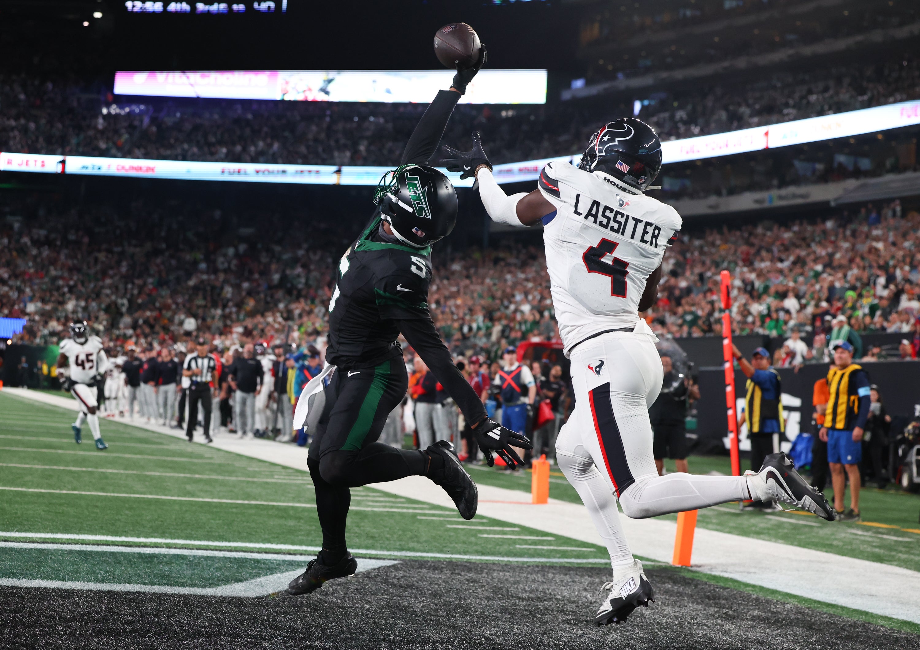 New York Jets wide receiver Garrett Wilson (5) catches a touchdown pass while being defended by Houston Texans cornerback Kamari Lassiter (4) during the second half at MetLife Stadium.