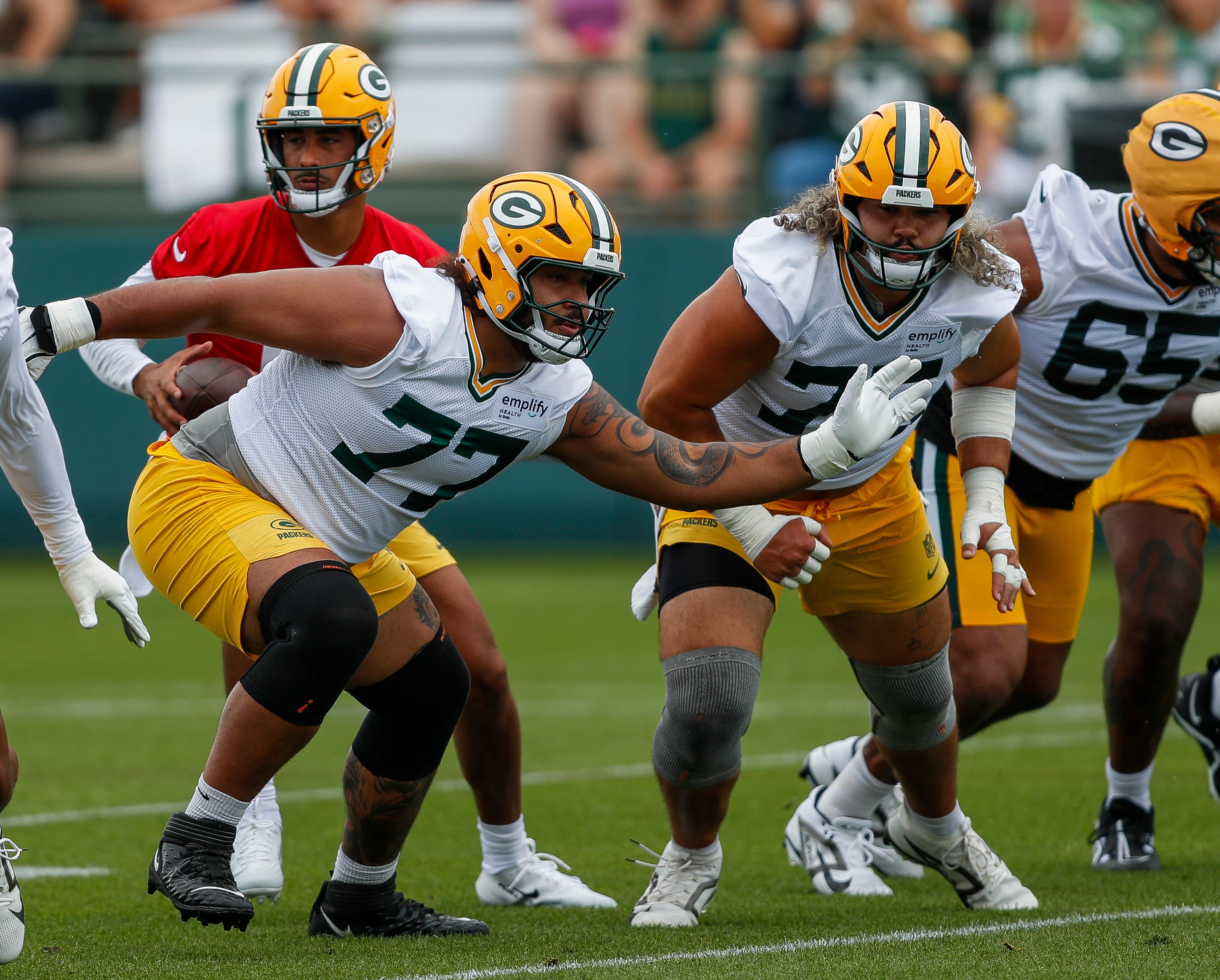 Green Bay Packers guard Jordan Morgan (77) runs through a drill during the first day of training camp on Wednesday, July 23, 2025, at Ray Nitschke Field in Ashwaubenon, Wis.