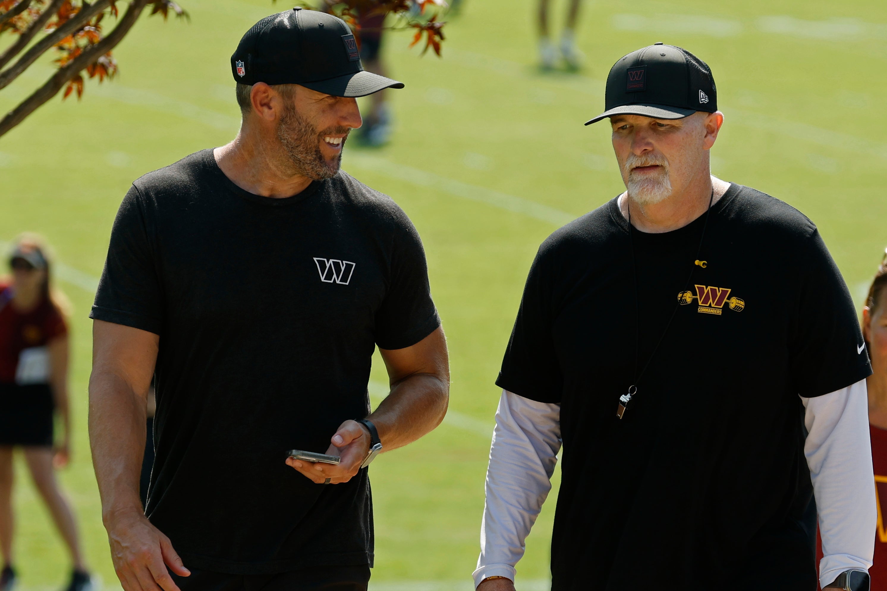 Jul 24, 2025; Ashburn, VA, USA; Washington Commanders general manager Adam Peters (L) talks with Commanders head coach Dan Quinn (R) while walking off the practice field on day two of training camp at OrthoVirginia Training Center at Commanders Park.
