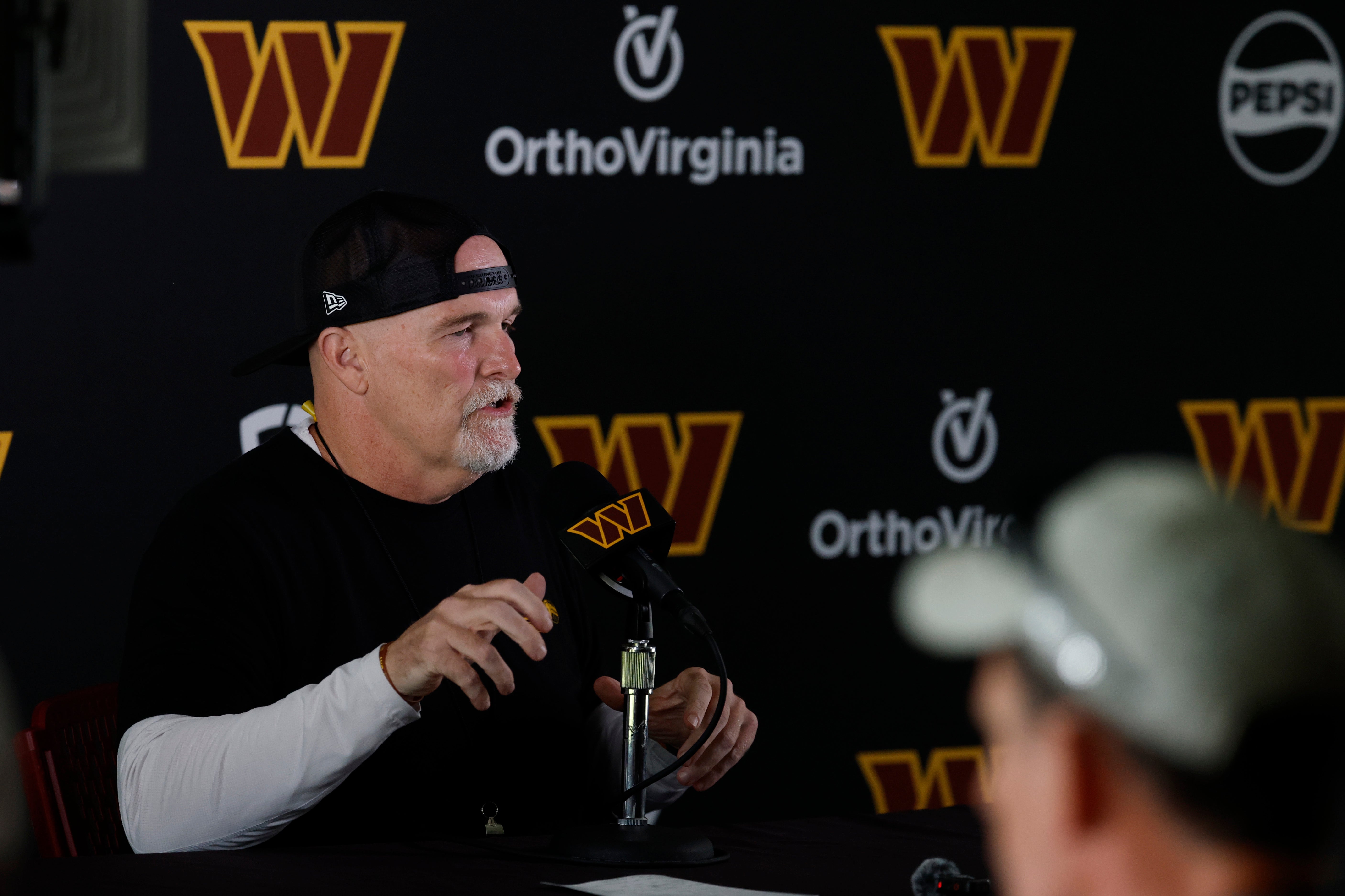 Jul 23, 2025; Ashburn, VA, USA; Washington Commanders head coach Dan Quinn speaks with the media prior to practice on day one of training camp at OrthoVirginia Training Center at Commanders Park.