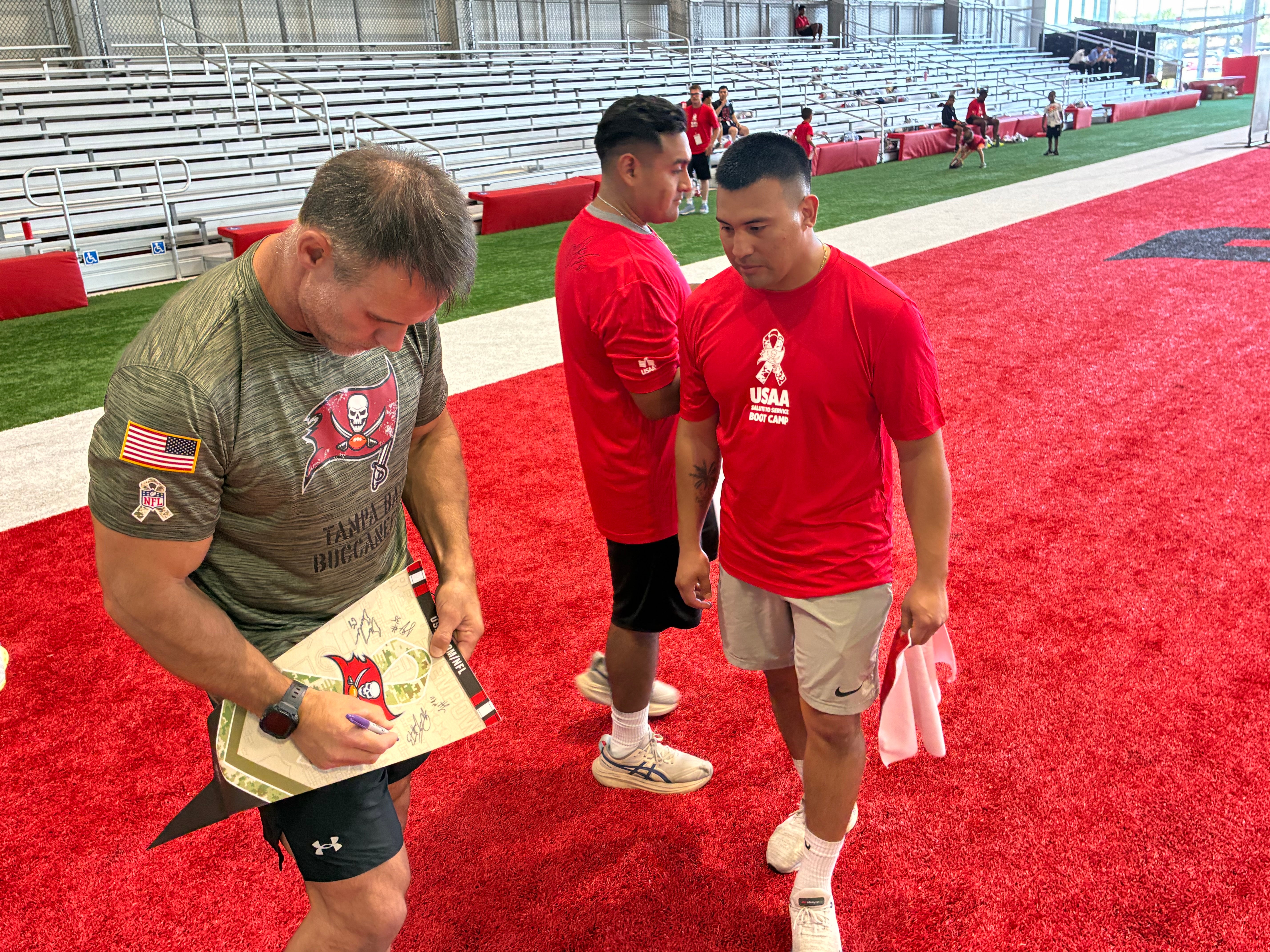 Mike Alstott signs an autograph for a member of the local Tampa Bay military after training camp practice.