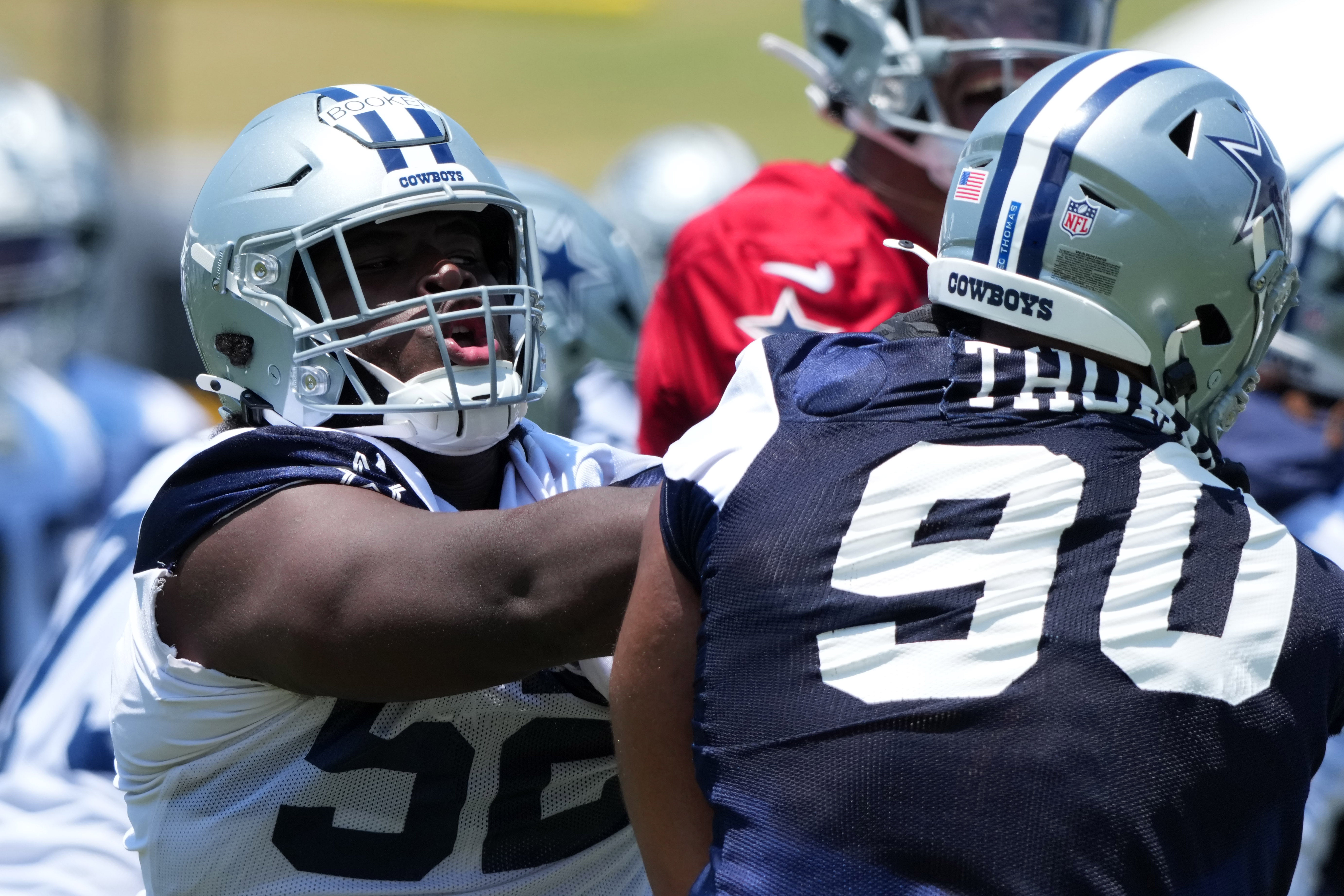 Dallas Cowboys guard Tyler Booker (52) defends against defensive tackle Solomon Thomas (90) during training camp at the River Ridge Fields.