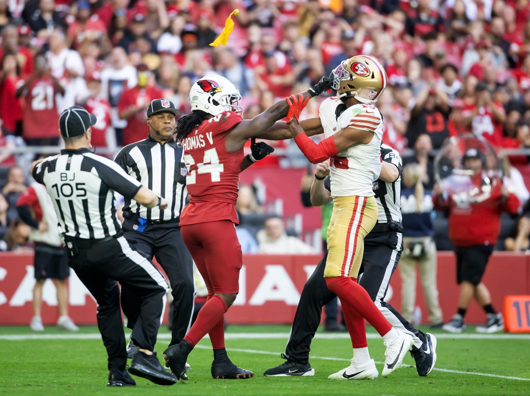 Referees throw yellow penalty flags as San Francisco 49ers wide receiver Jauan Jennings (15) fights Arizona Cardinals cornerback Starling Thomas V (24) in the first half at State Farm Stadium.