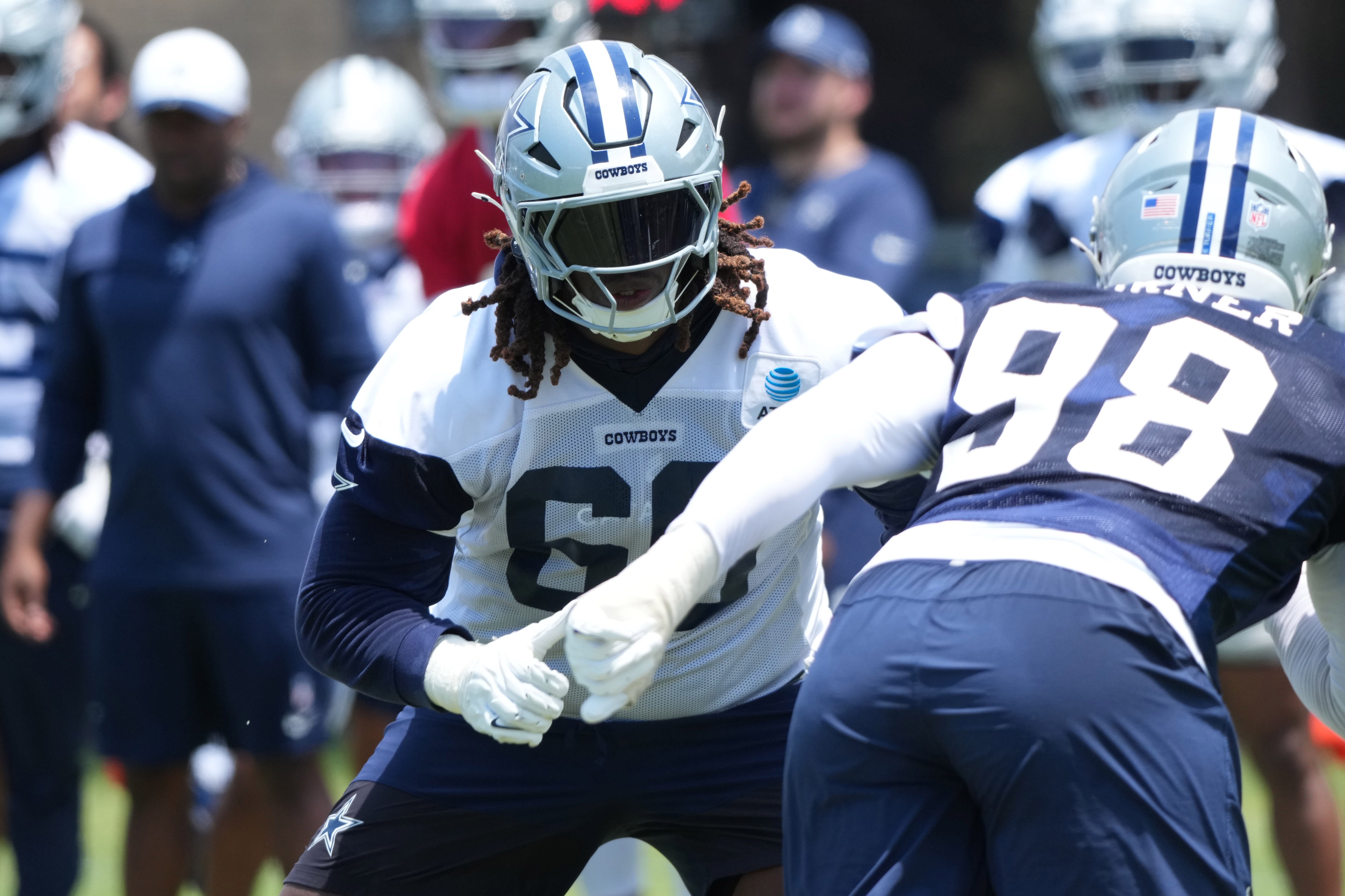 Dallas Cowboys tackle Tyler Guyton (60) defends against defensive end Payton Turner (98) during training camp at the River Ridge Fields.