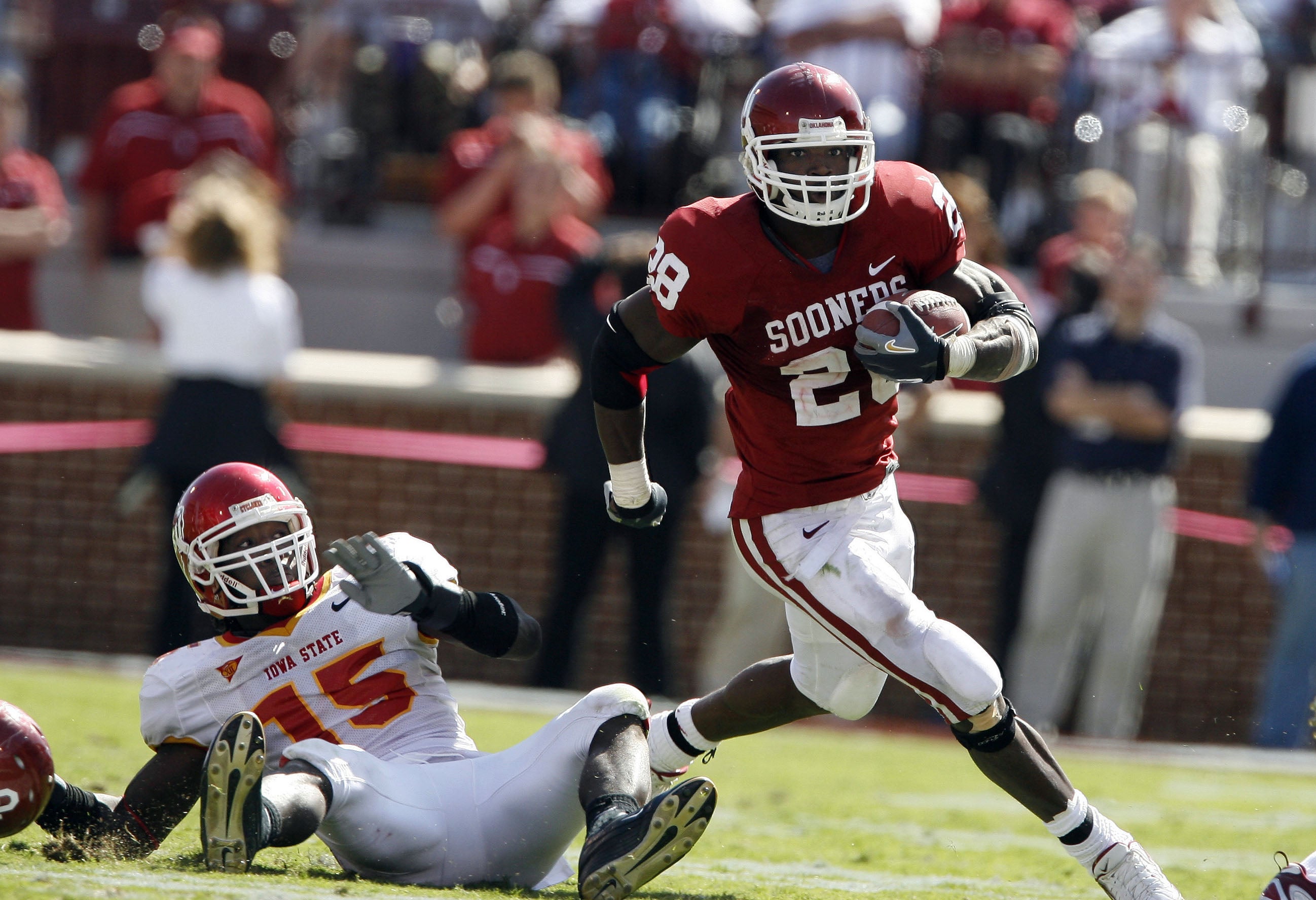 Oct 14, 2006; Norman, OK, USA; Oklahoma Sooners running back (28) Adrian Peterson runs the ball for a 53 yard fourth quarter touchdown against Iowa State Cyclones linebacker (15) Alvin Bowen at Oklahoma Memorial Stadium. The Sooners beat the Cyclones 34-9.