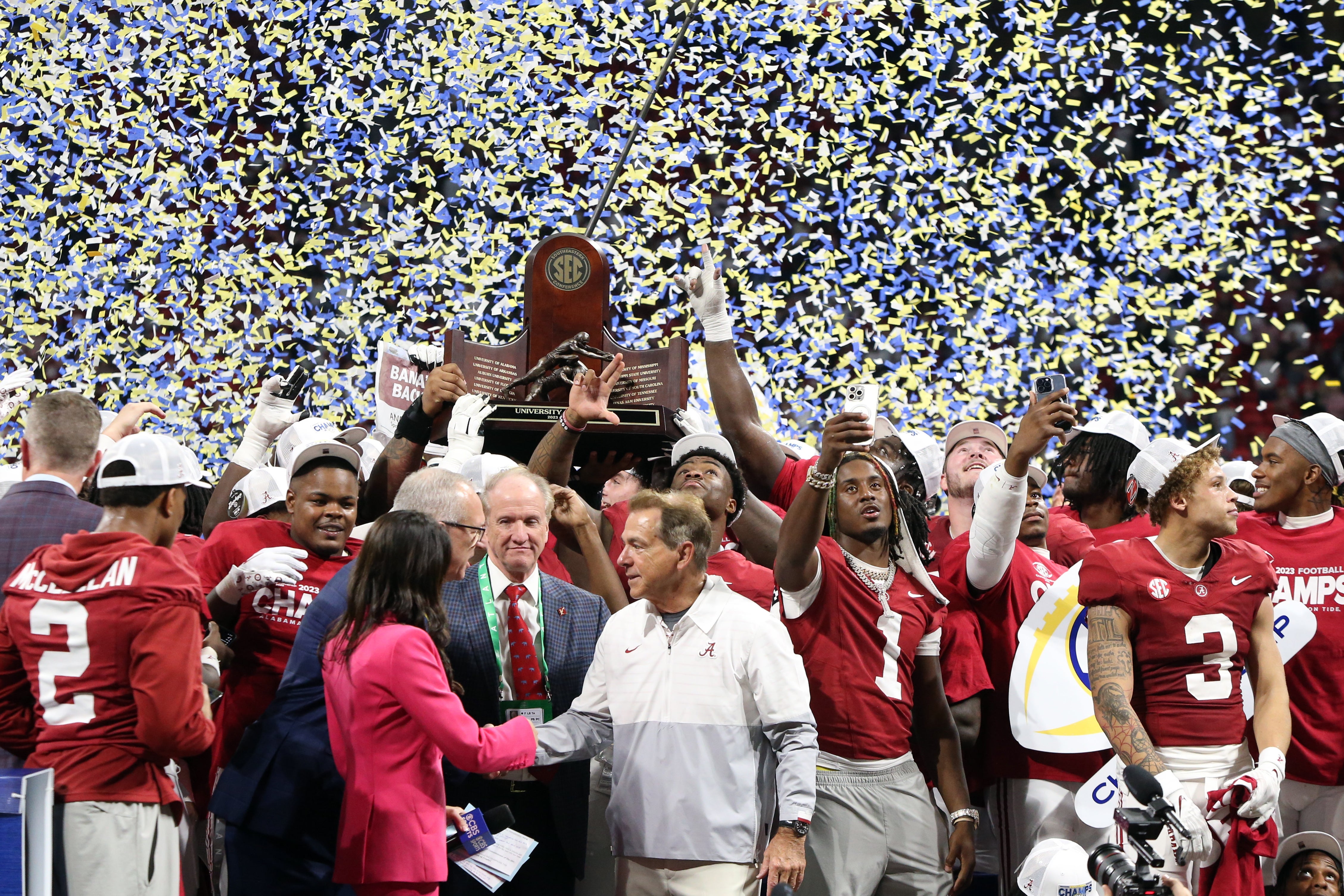 Dec 2, 2023; Atlanta, GA, USA; Alabama Crimson Tide head coach Nick Saban and players celebrate with the trophy on the podium after defeating the Georgia Bulldogs in the SEC championship game at Mercedes-Benz Stadium.