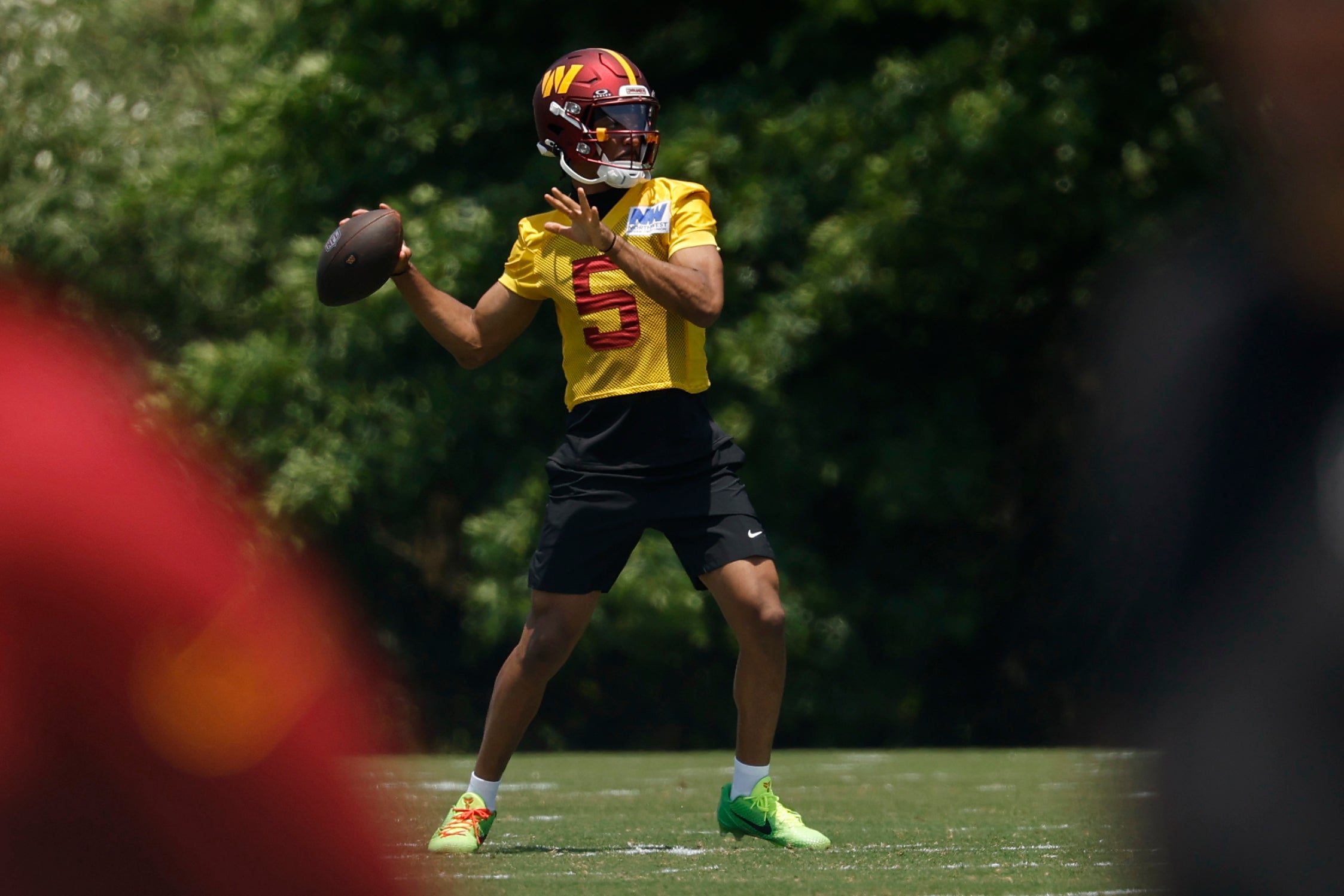 Washington Commanders quarterback Jayden Daniels (5) passes the ball on day one of minicamp at Commanders Park.