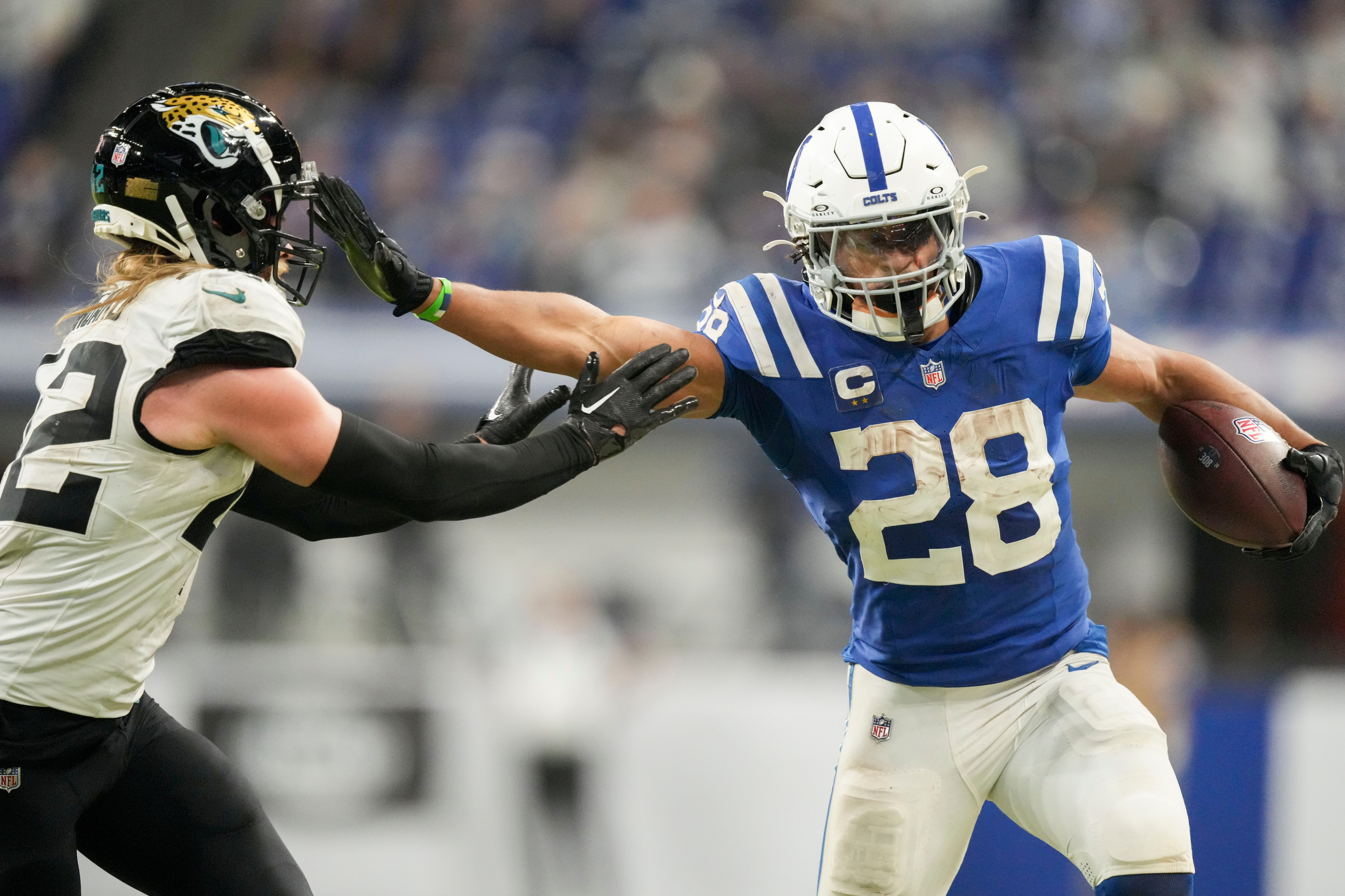 Indianapolis Colts running back Jonathan Taylor (28) pushes off Jacksonville Jaguars cornerback De'Antre Prince (24) as he rushes the ball Sunday, Jan. 5, 2025, during a game against the Jacksonville Jaguars at Lucas Oil Stadium in Indianapolis.
