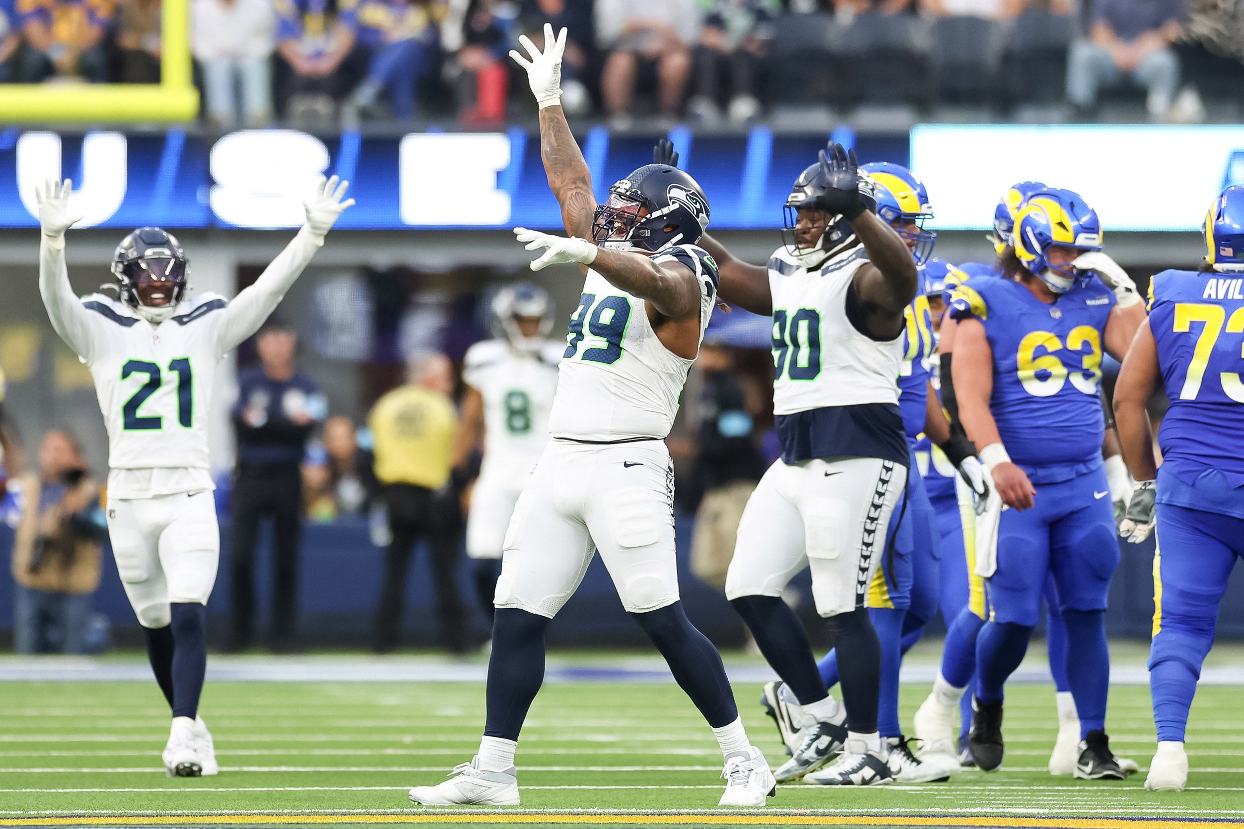 Seattle Seahawks Defensive End Leonard Williams (99), Free Safety Devon Witherspoon (21) and Nose Tackle Jarred Reed (90) celebrate a 4th down stop at SoFi Stadium, as the Seattle Seahawks face off versus the Los Angeles Rams in Week 18.