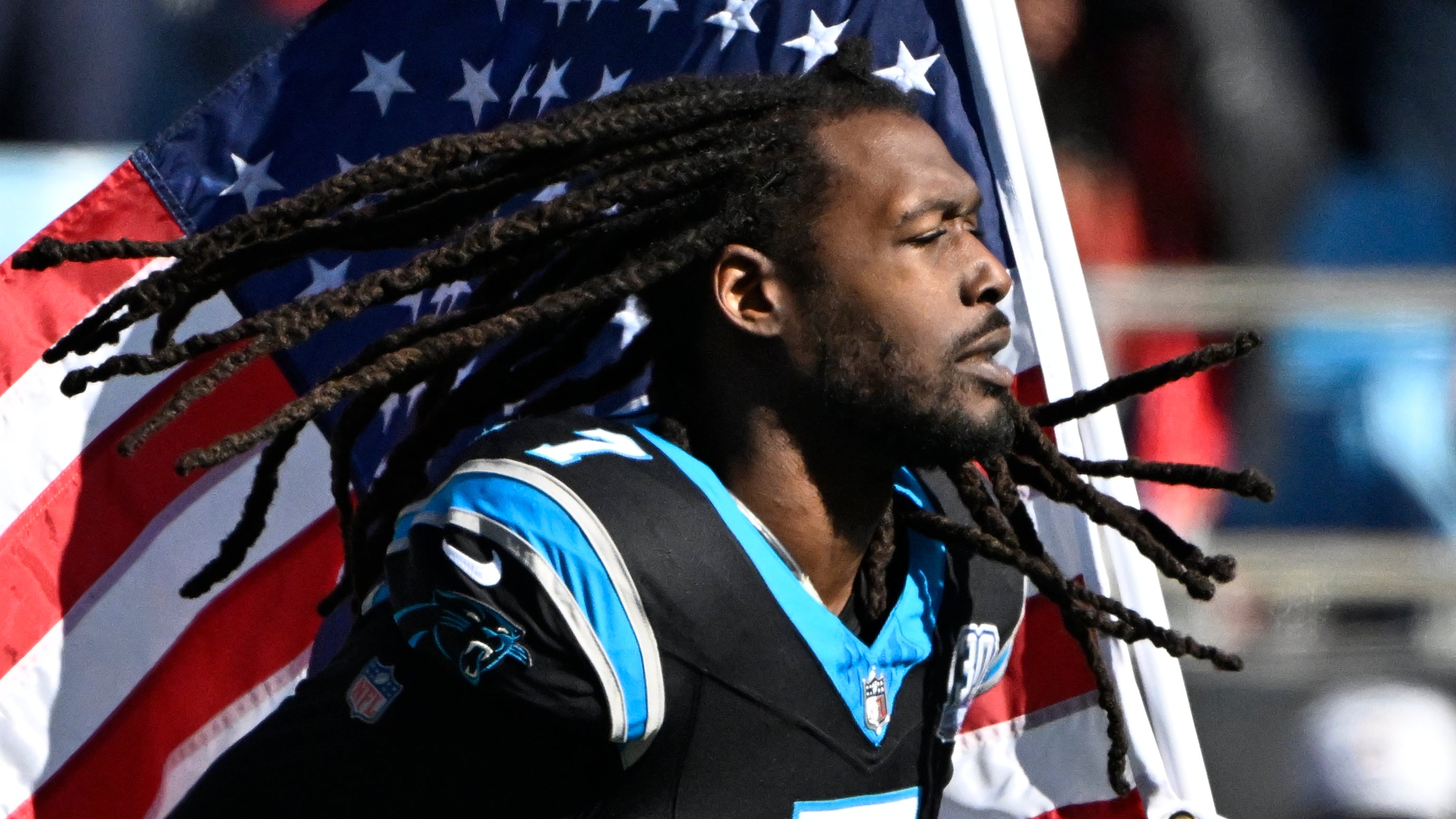 Carolina Panthers linebacker Jadeveon Clowney (7) runs on to the field with the american flag before the game at Bank of America Stadium. 