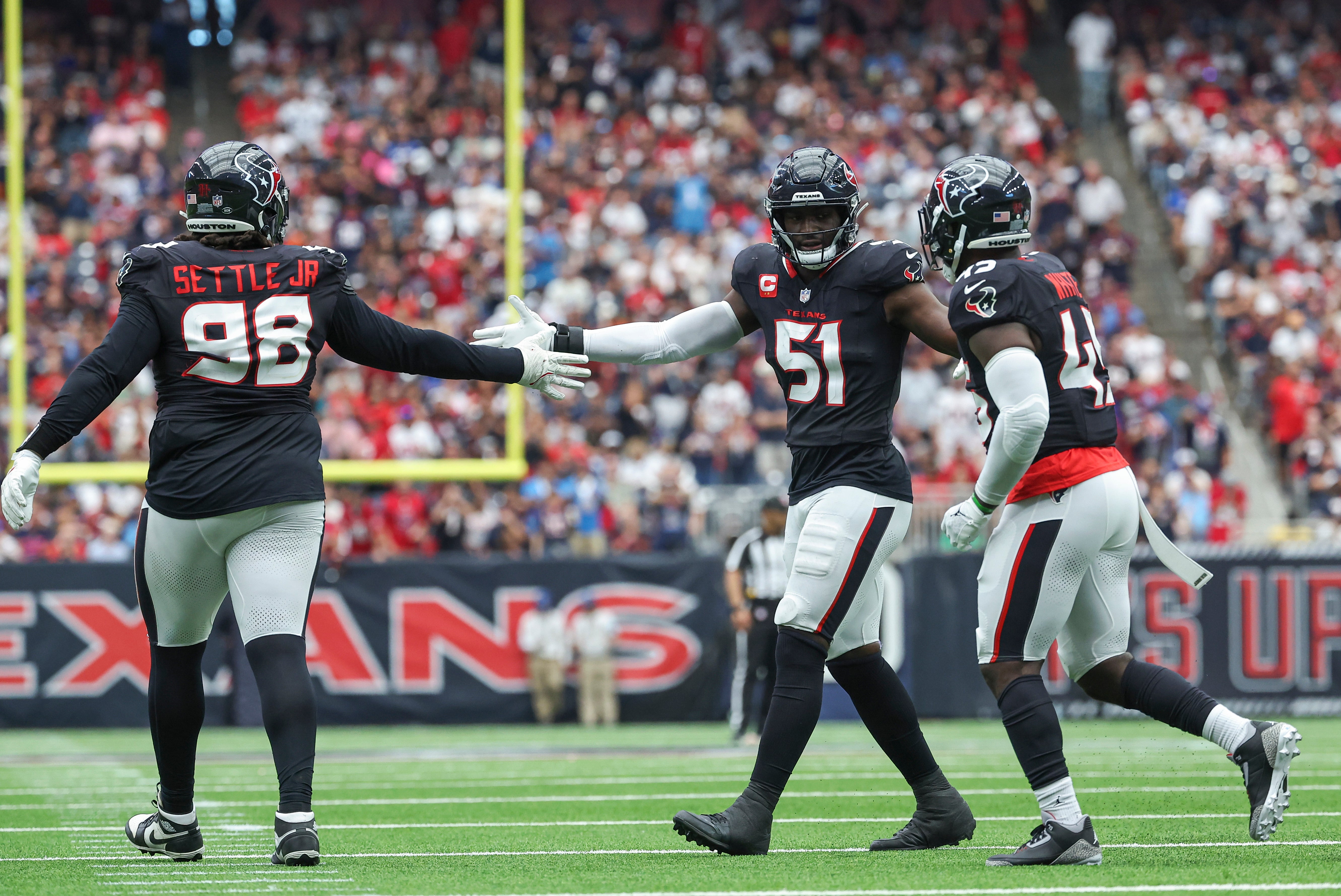 Houston Texans defensive end Will Anderson Jr. (51) congratulates defensive tackle Tim Settle Jr. (98) and linebacker Devin White (45) after a play during the game against the Indianapolis Colts at NRG Stadium.